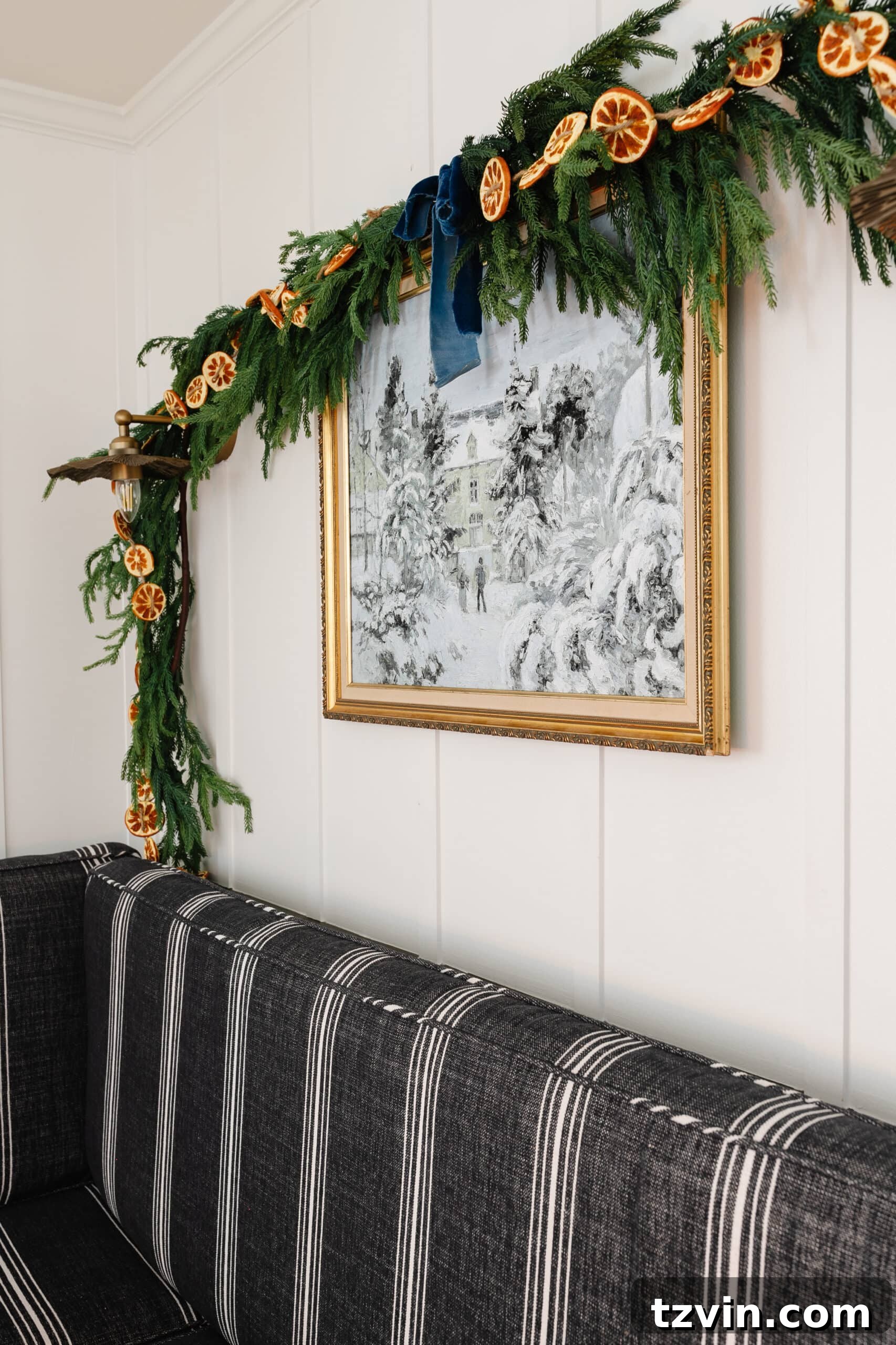 Instant Winter Art: Free Printable Decor 3 Charming winter painting in a gold thrifted frame, adorned with pine garland and dried orange slices for festive holiday decor.