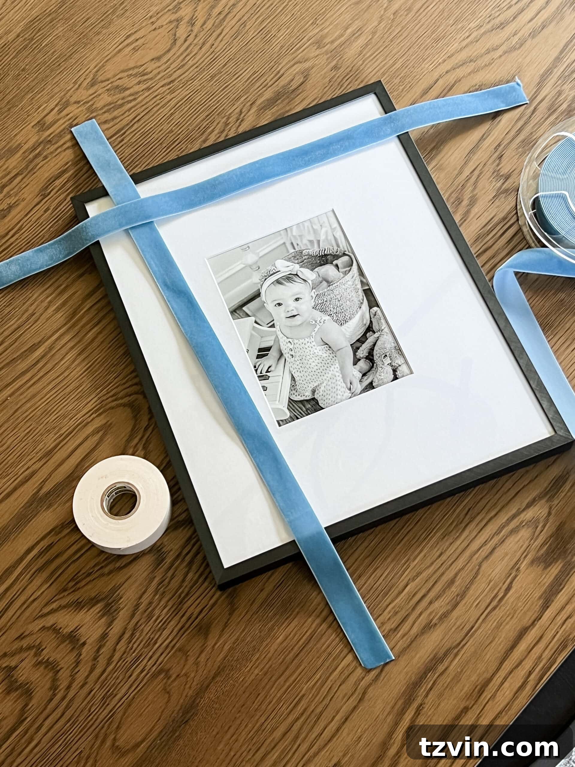 Effortless 5 Minute Holiday Ribbon Art 4 A close-up view of hands carefully cutting a length of festive ribbon to wrap around a picture frame for a DIY Christmas decoration.