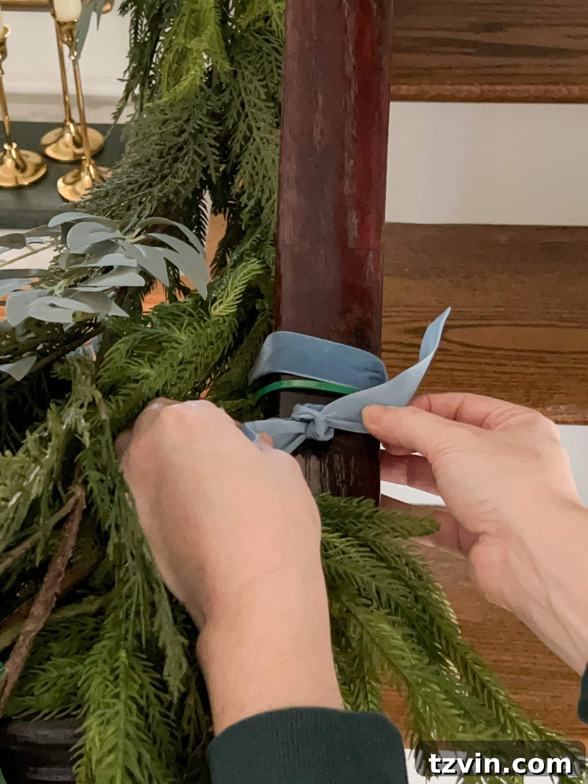Sparkling Stairs and Welcoming Entryways: Your Garland Decor Guide 11 adding ribbon to cover zip ties on staircase garland