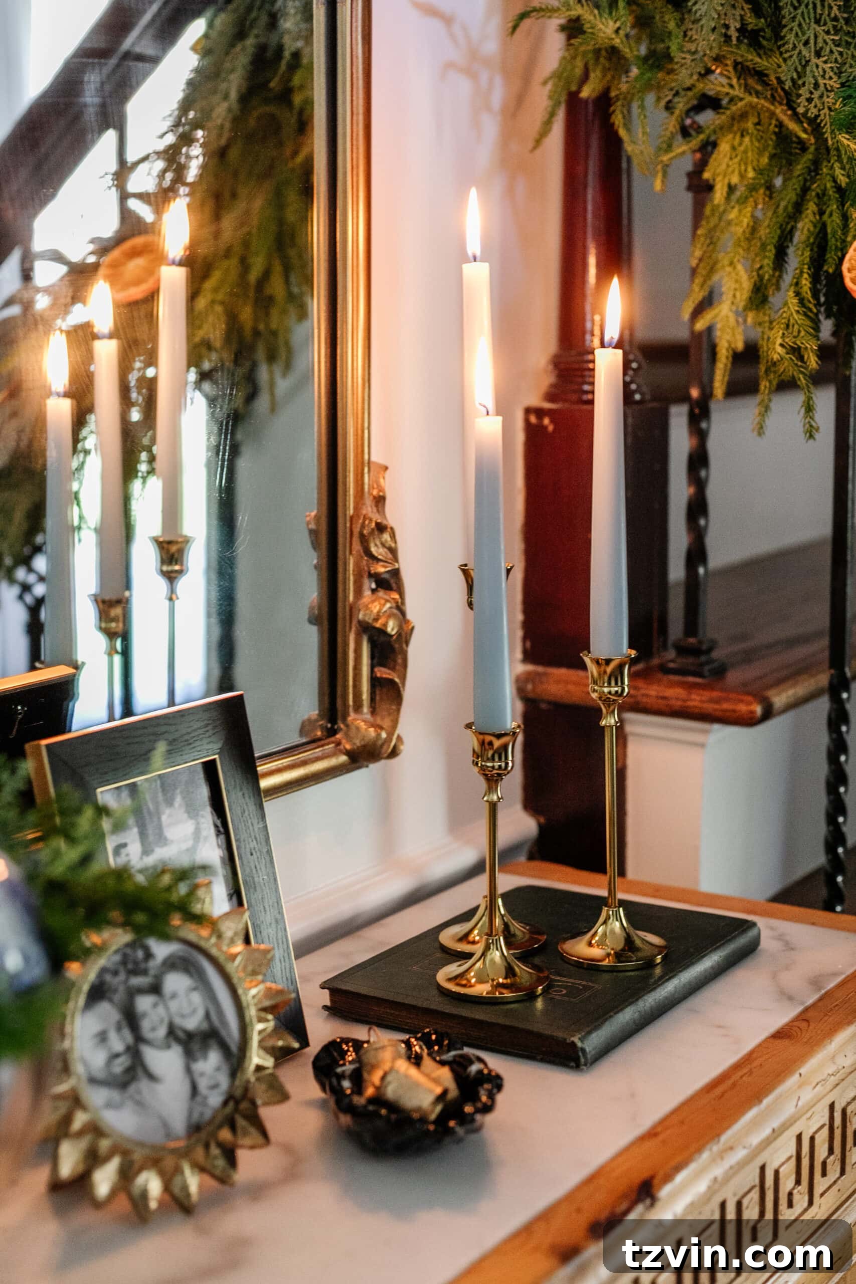 Sparkling Stairs and Welcoming Entryways: Your Garland Decor Guide 16 brass candlesticks with blue candles on an entryway table