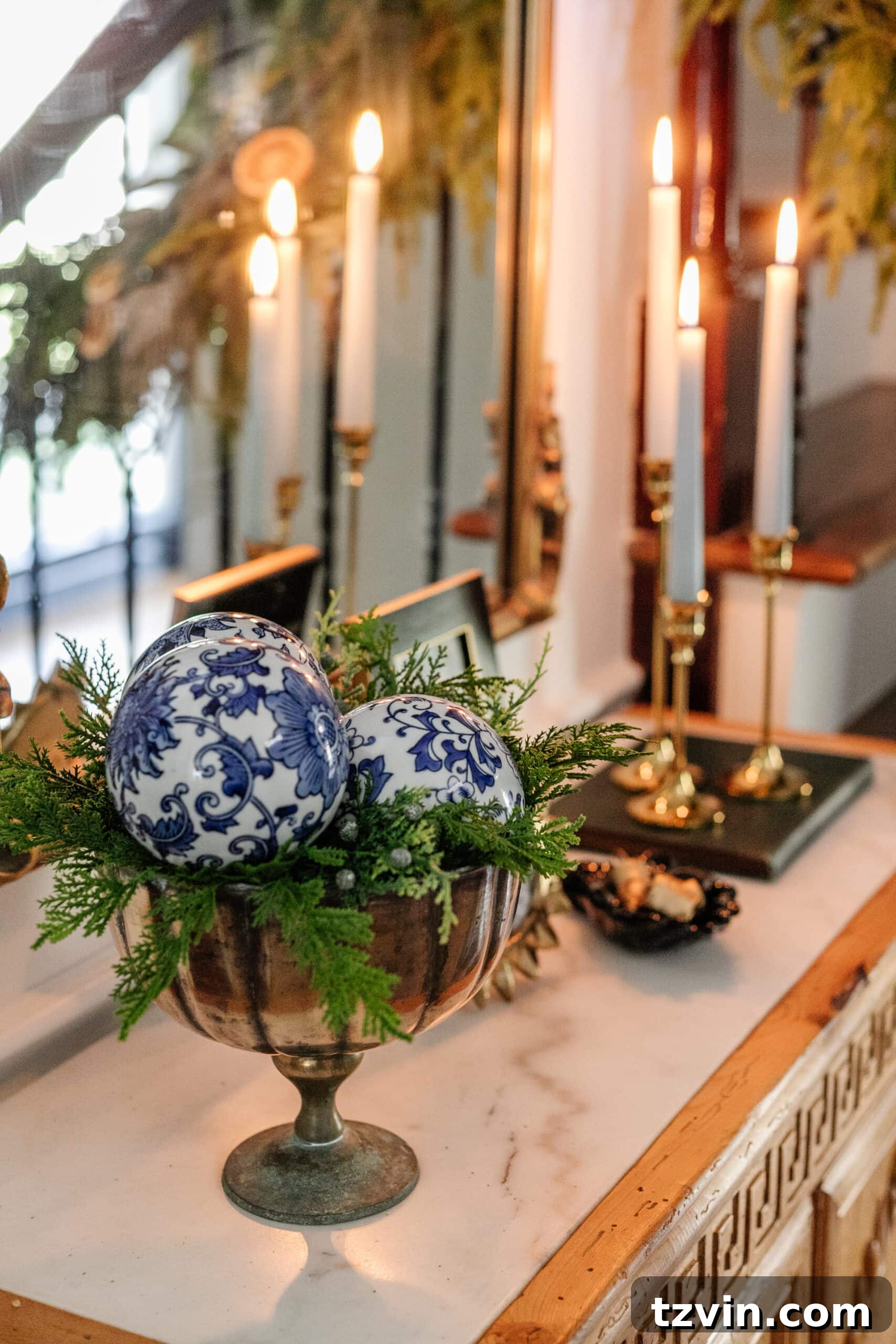 Sparkling Stairs and Welcoming Entryways: Your Garland Decor Guide 17 porcelain orbs in a footed bowl with greenery on an entryway table for blue and white Christmas decor