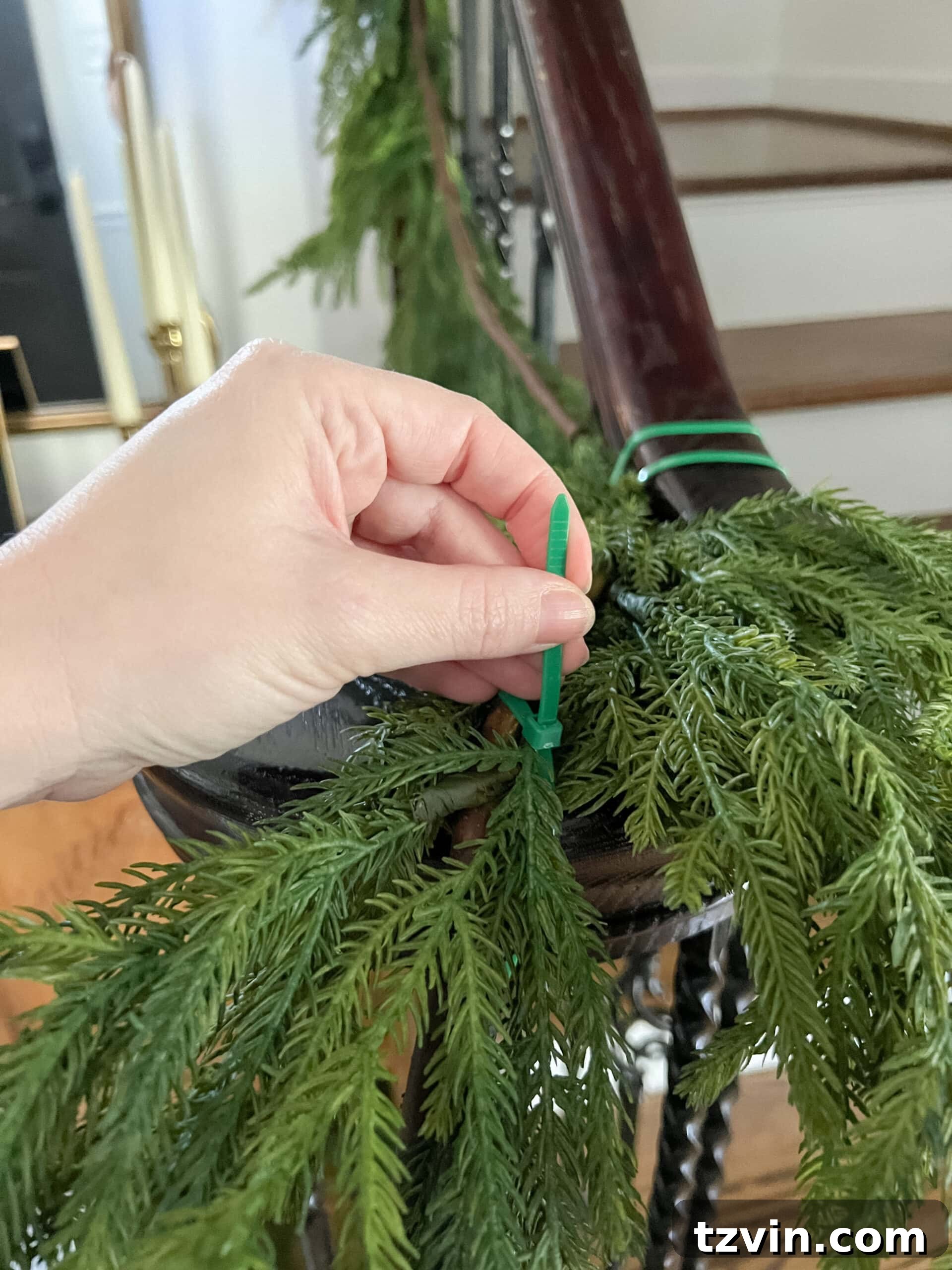 Sparkling Stairs and Welcoming Entryways: Your Garland Decor Guide 6 connecting garland on stairs banister with zip ties for a continuous look