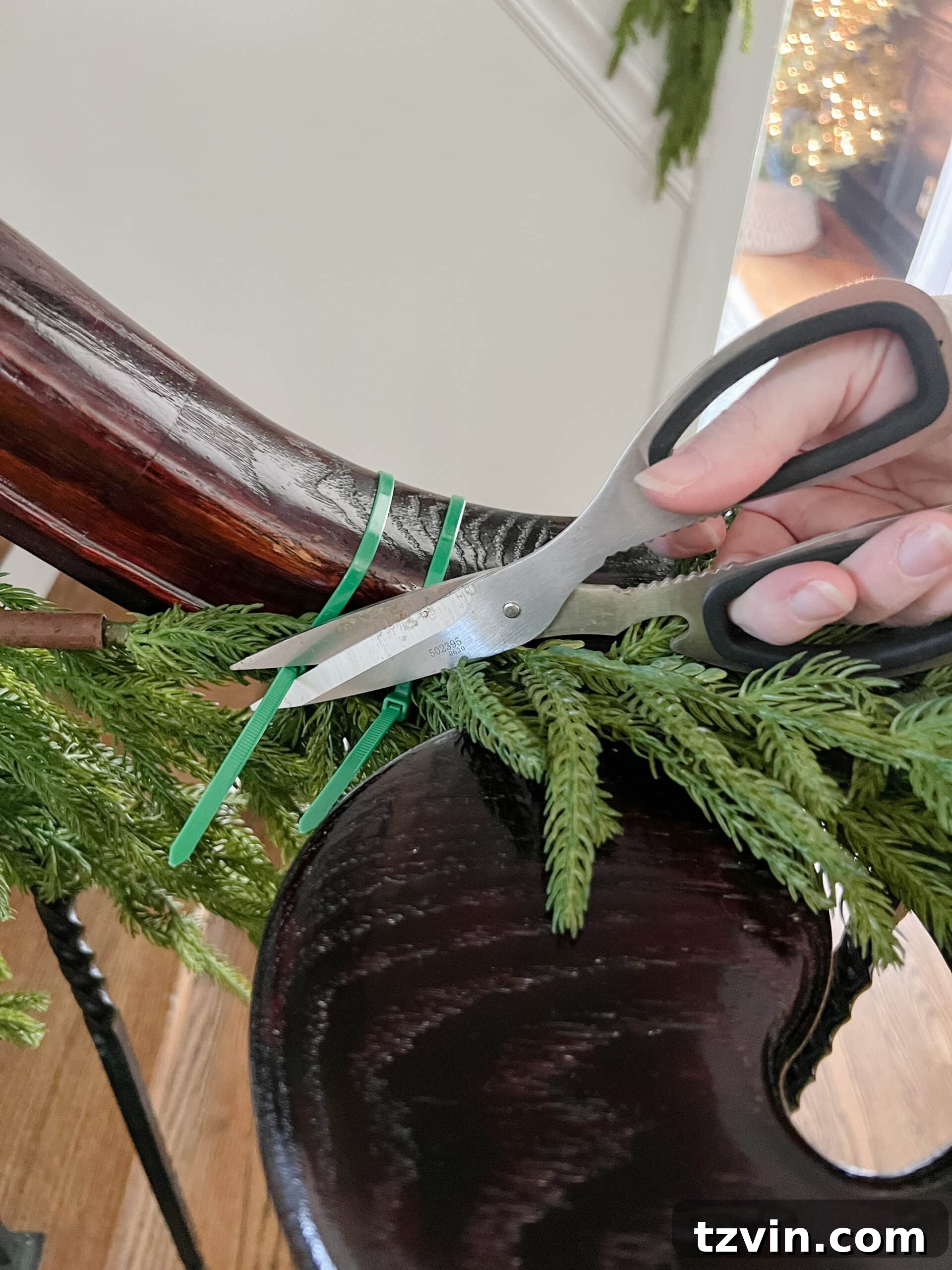 Sparkling Stairs and Welcoming Entryways: Your Garland Decor Guide 7 cutting zip ties with scissors on staircase garland