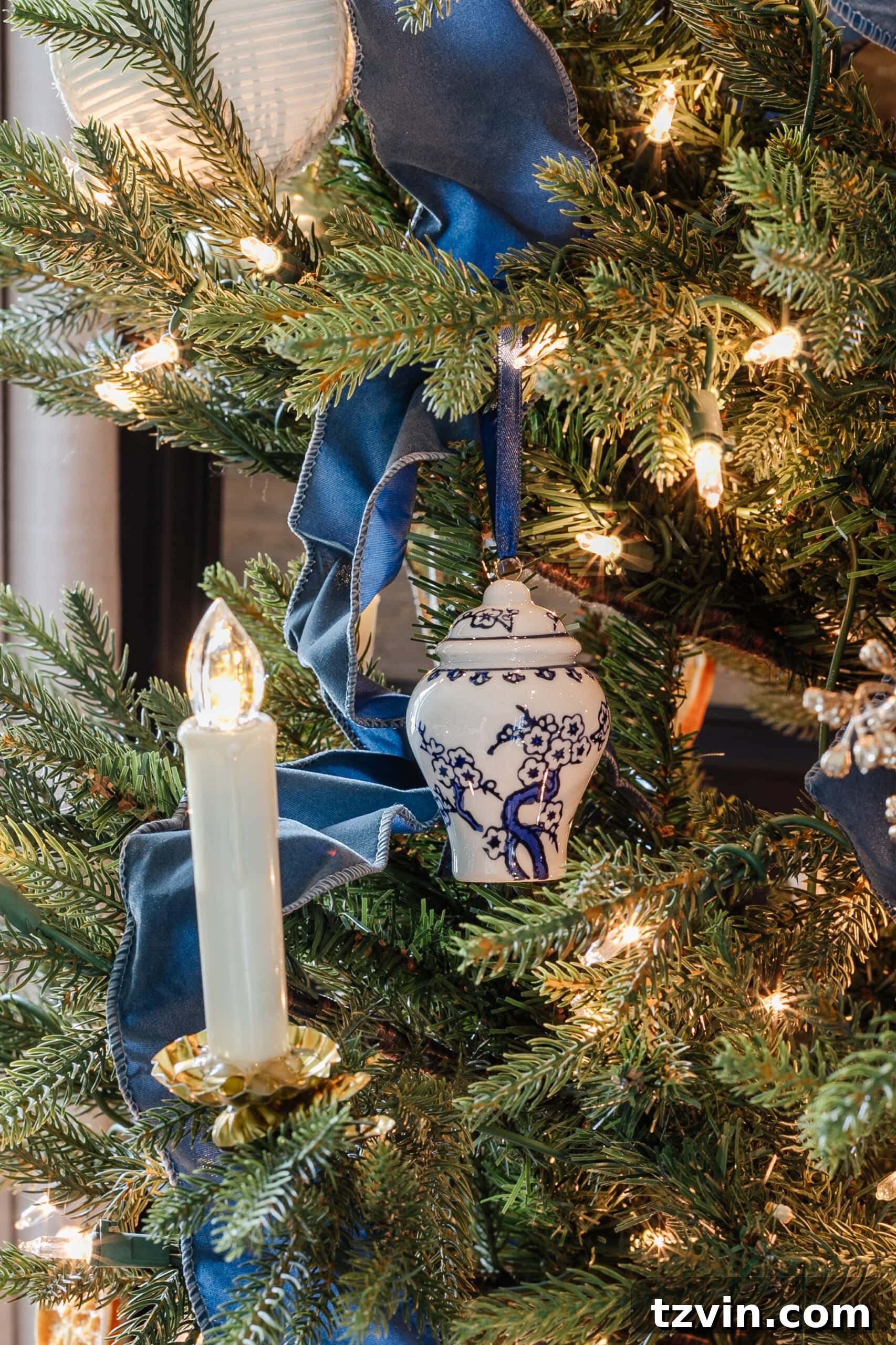 Festive Dining: White and Blue Christmas Inspiration 11 Blue ribbon and white and blue ornaments on a Christmas tree.