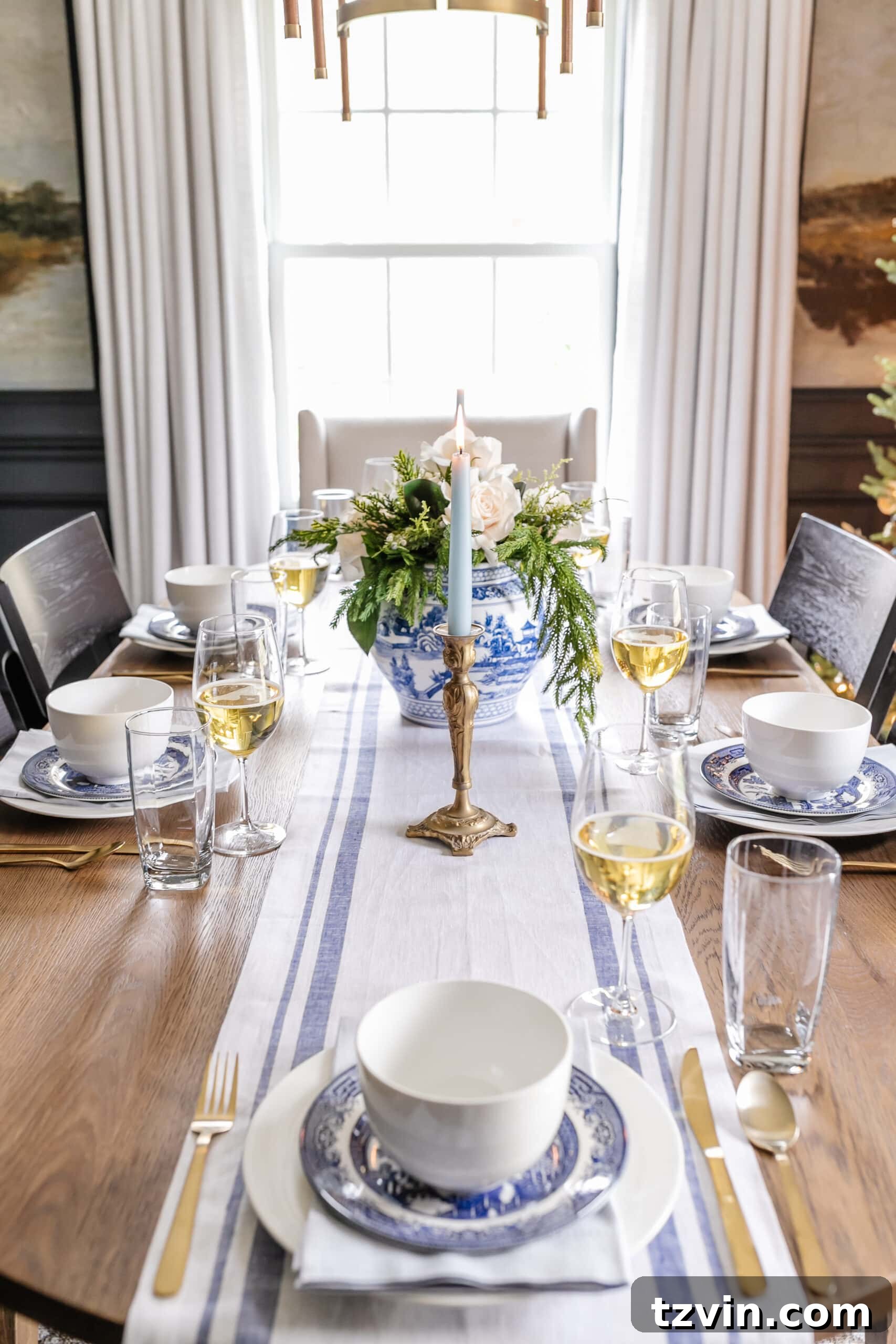 Festive Dining: White and Blue Christmas Inspiration 5 White and blue Christmas dinner table decor featuring candles, a centerpiece, linens, and dinnerware.