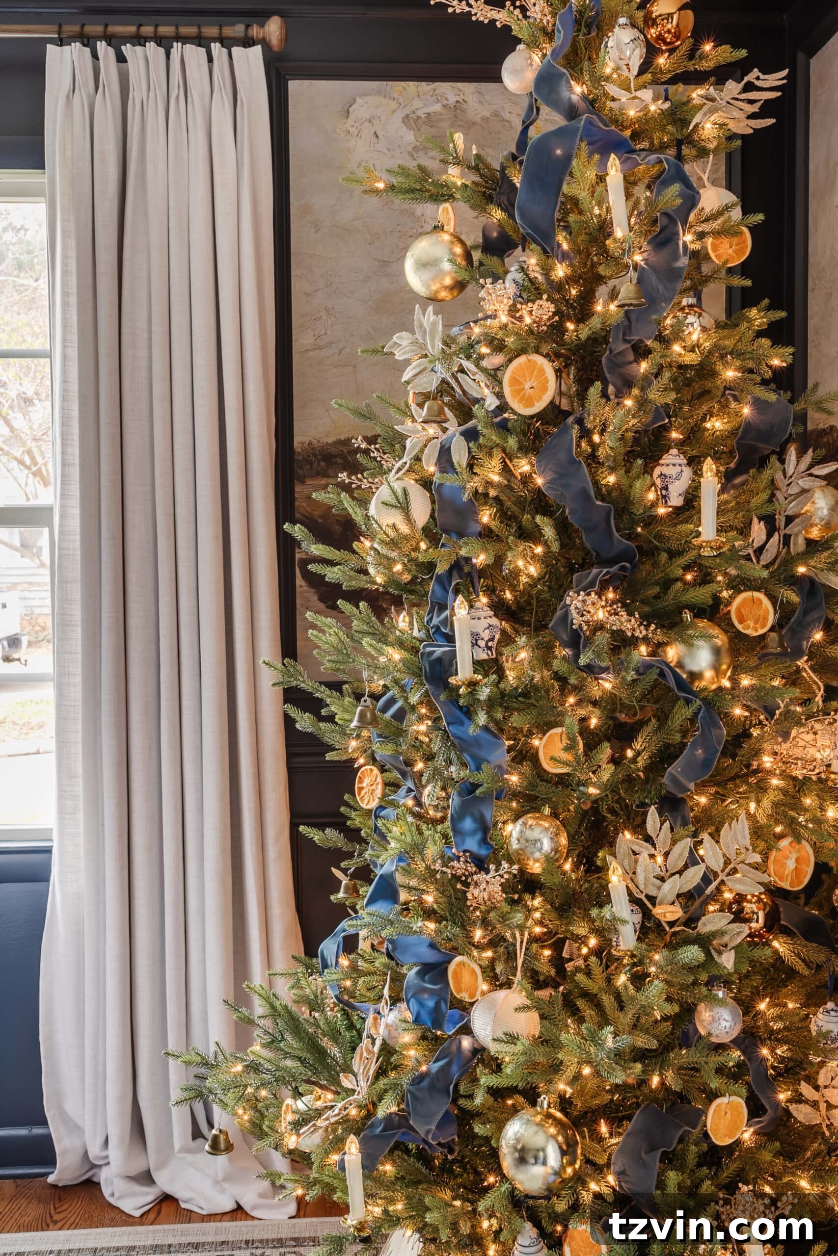 Festive Dining: White and Blue Christmas Inspiration 10 Blue Christmas tree with ribbon, oranges, and neutral ornaments.