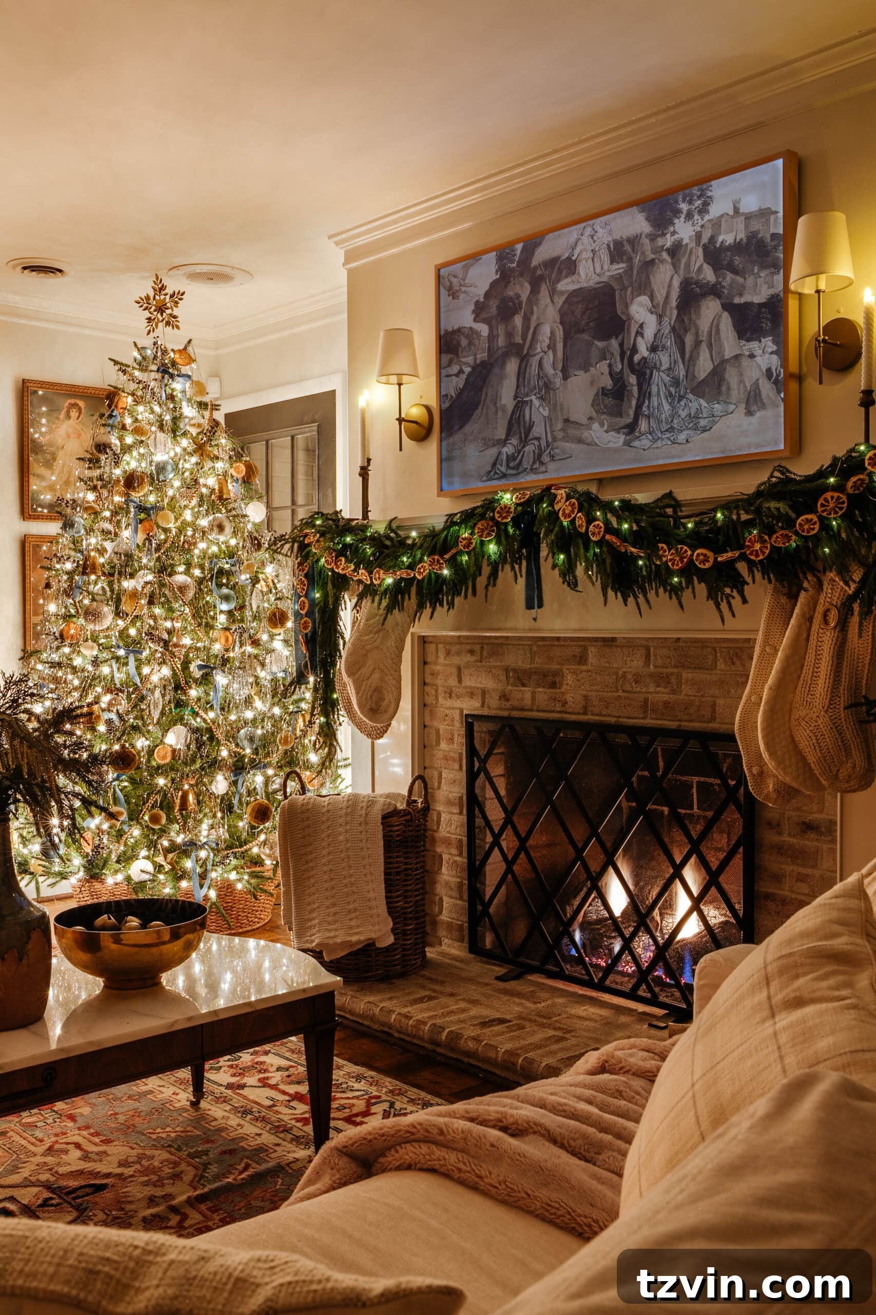 A beautifully decorated entryway table with festive greenery, candles, and a mirror, illuminated by soft holiday lighting.