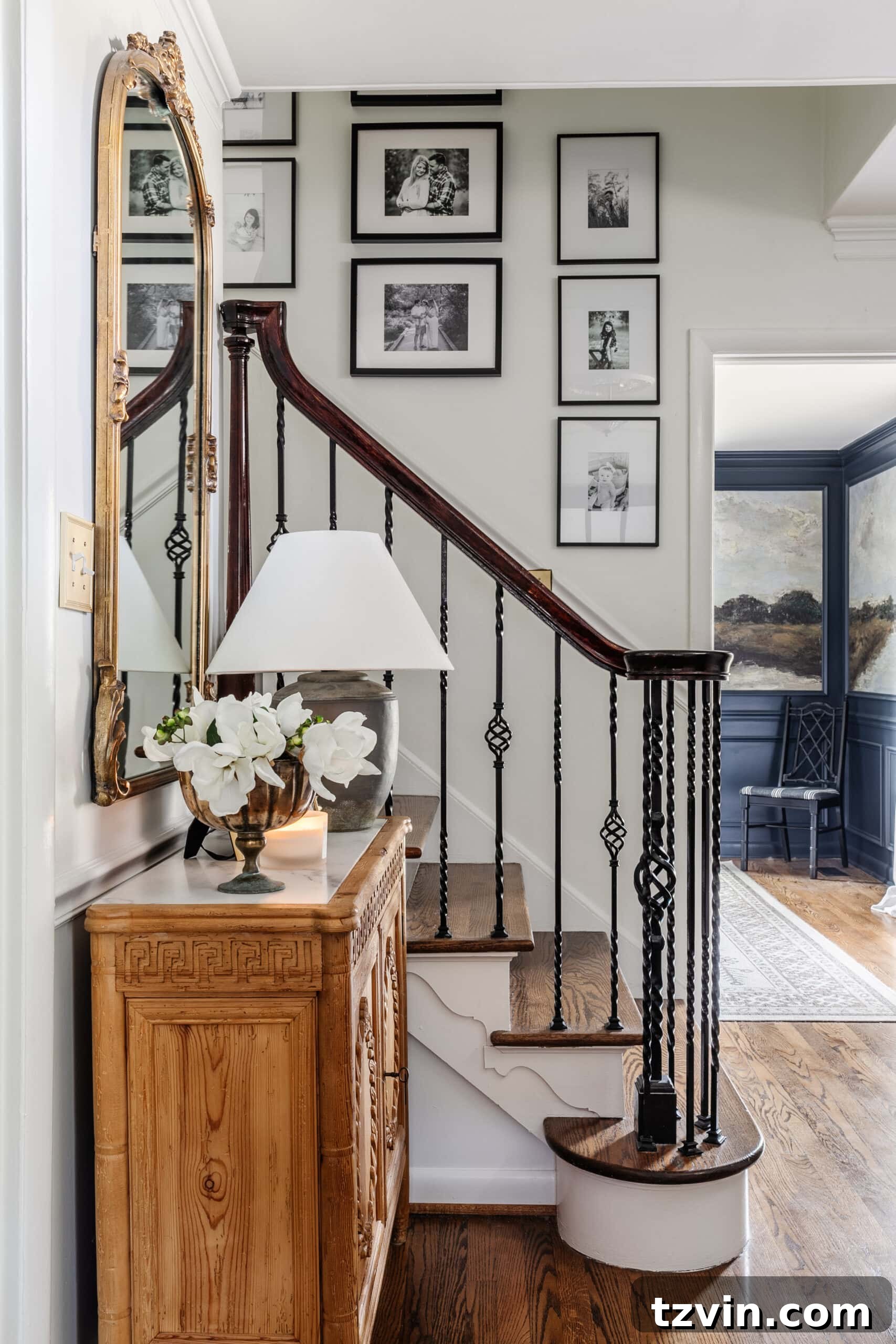 Black Stair Railing Ideas for a Dramatic Entry 2 Entryway staircase with black and white gallery wall