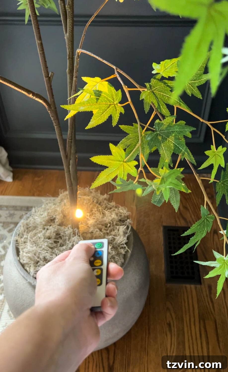 Beyond Plastic: Making Your Artificial Indoor Trees Look Naturally Real 8 adding an uplight to a fake tree with a remote