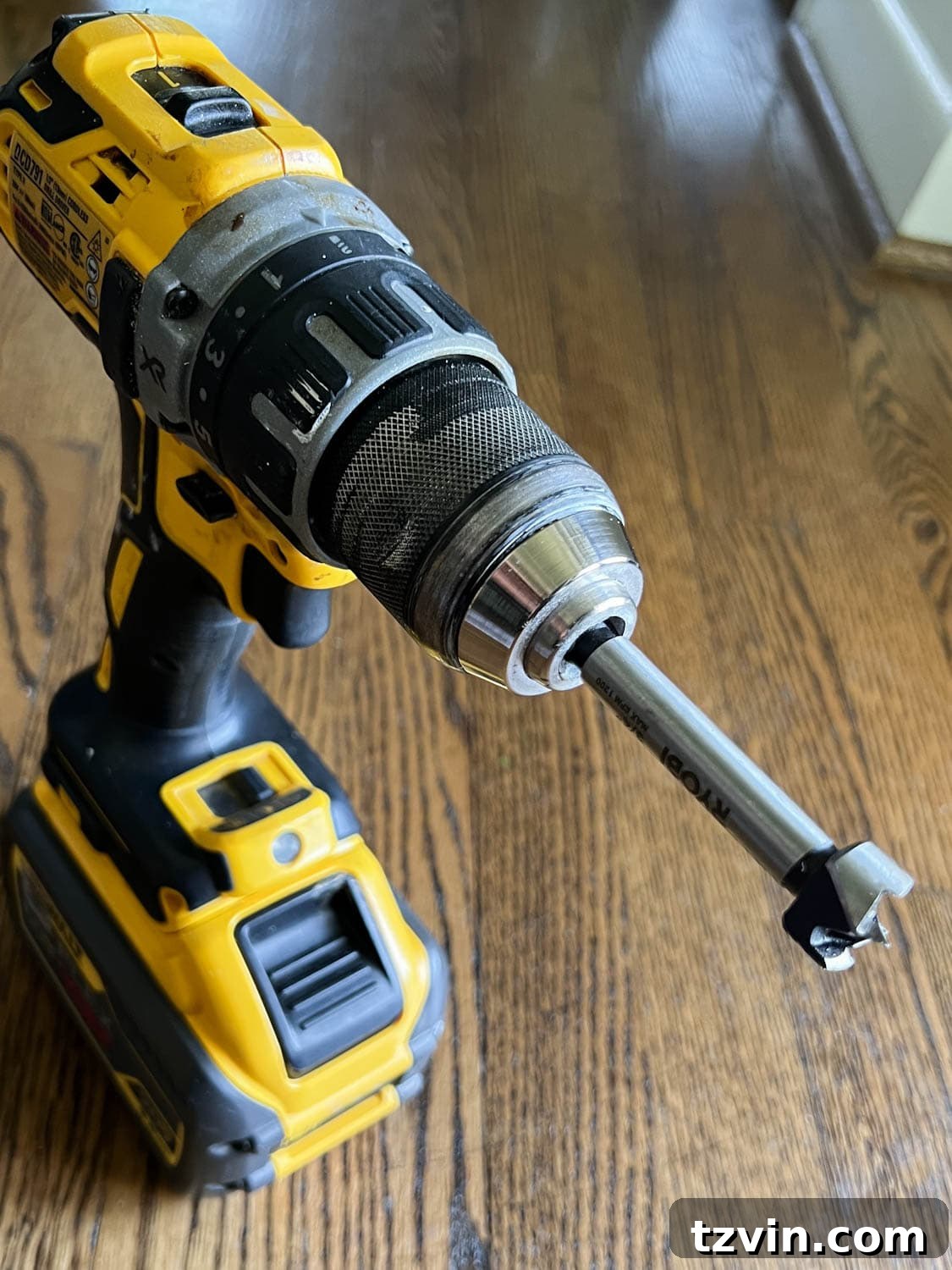 Revamp Your Stairs: DIY Spindle Replacement 11 a forstner drill bit on a drill for removing old adhesive in stair treads