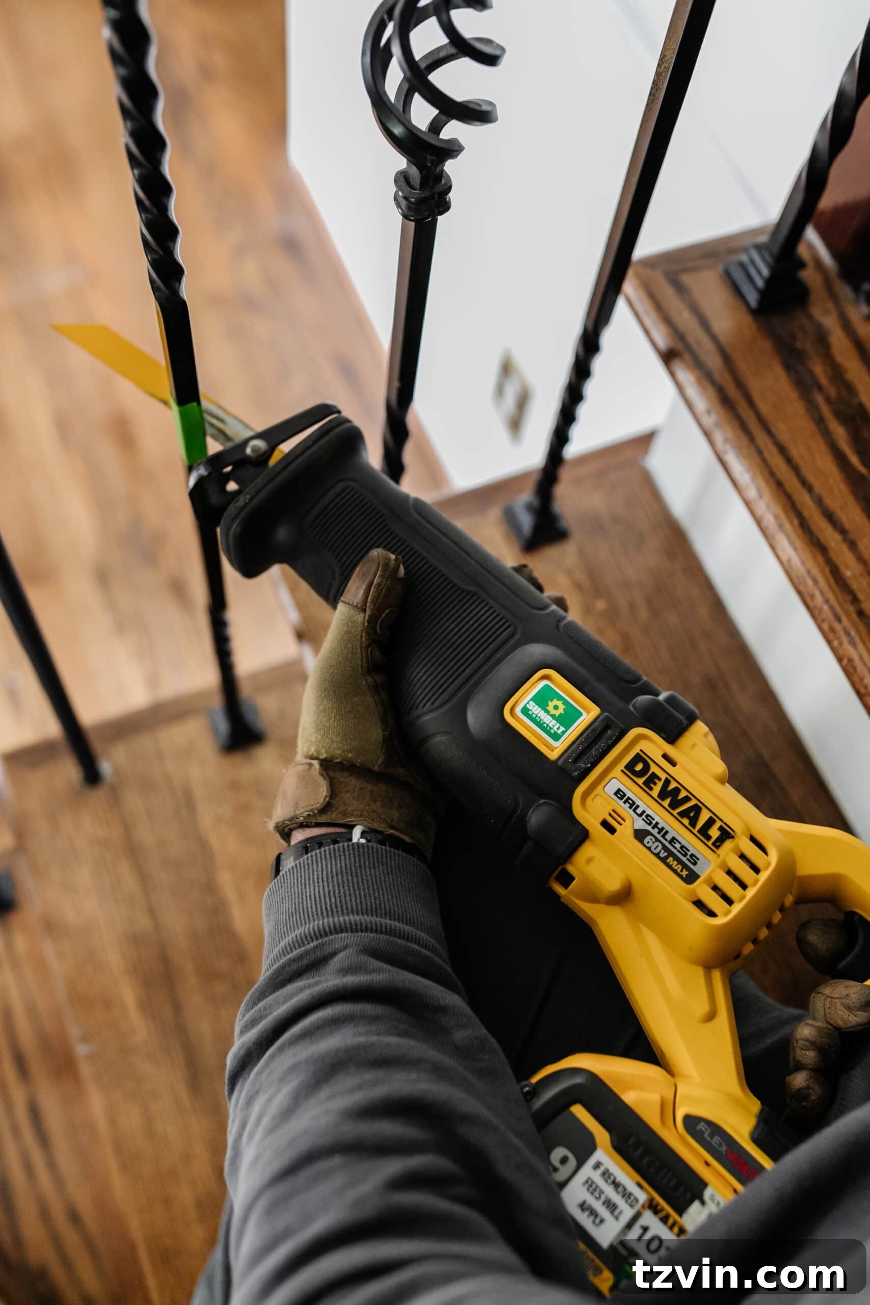 Revamp Your Stairs: DIY Spindle Replacement 7 close up of cutting wrought iron stair balusters with a reciprocating saw
