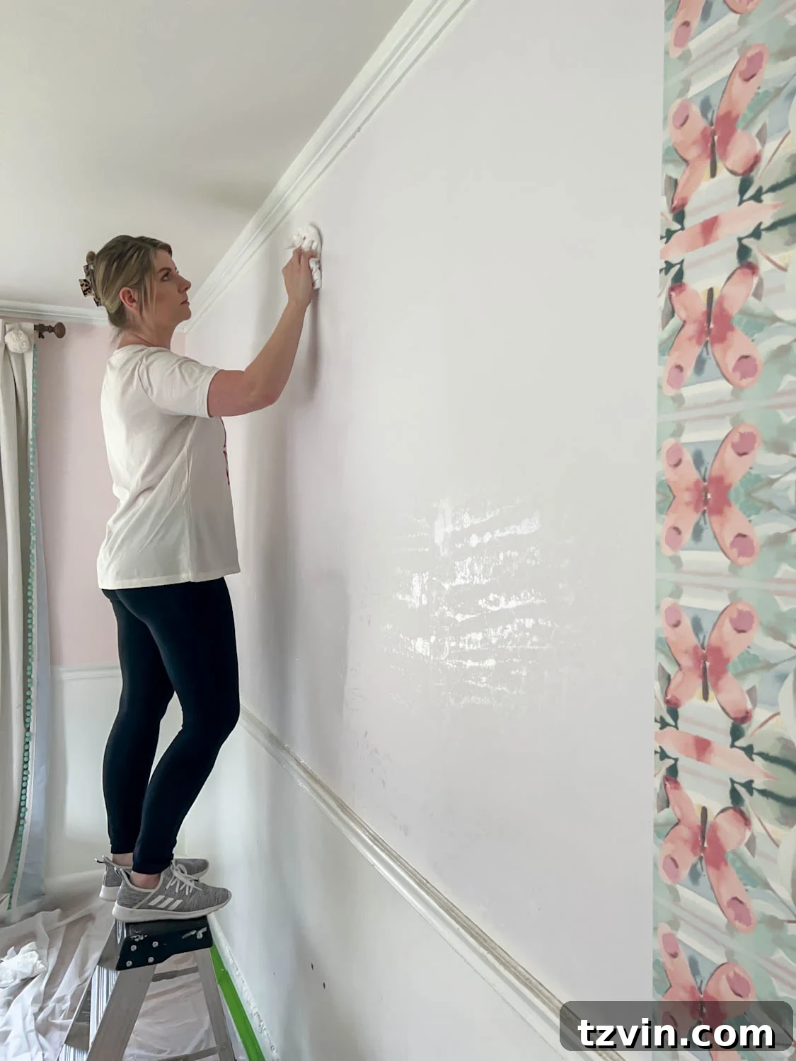 Cleaning adhesive off of wall after wallpaper stripping is complete
