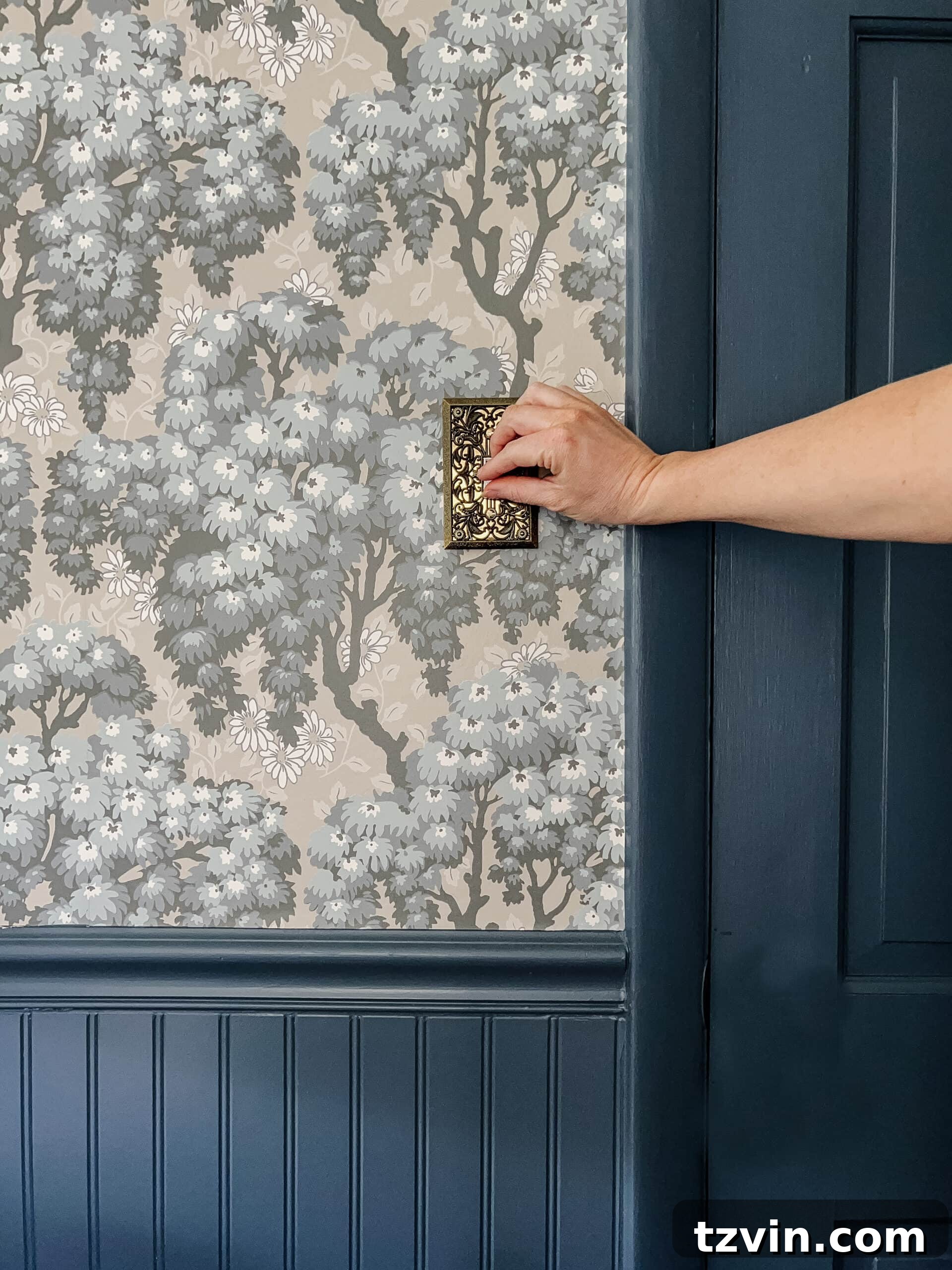 Elegant vintage light switch cover contrasting with Swedish wallpaper and Sherwin Williams Smoky Blue beadboard