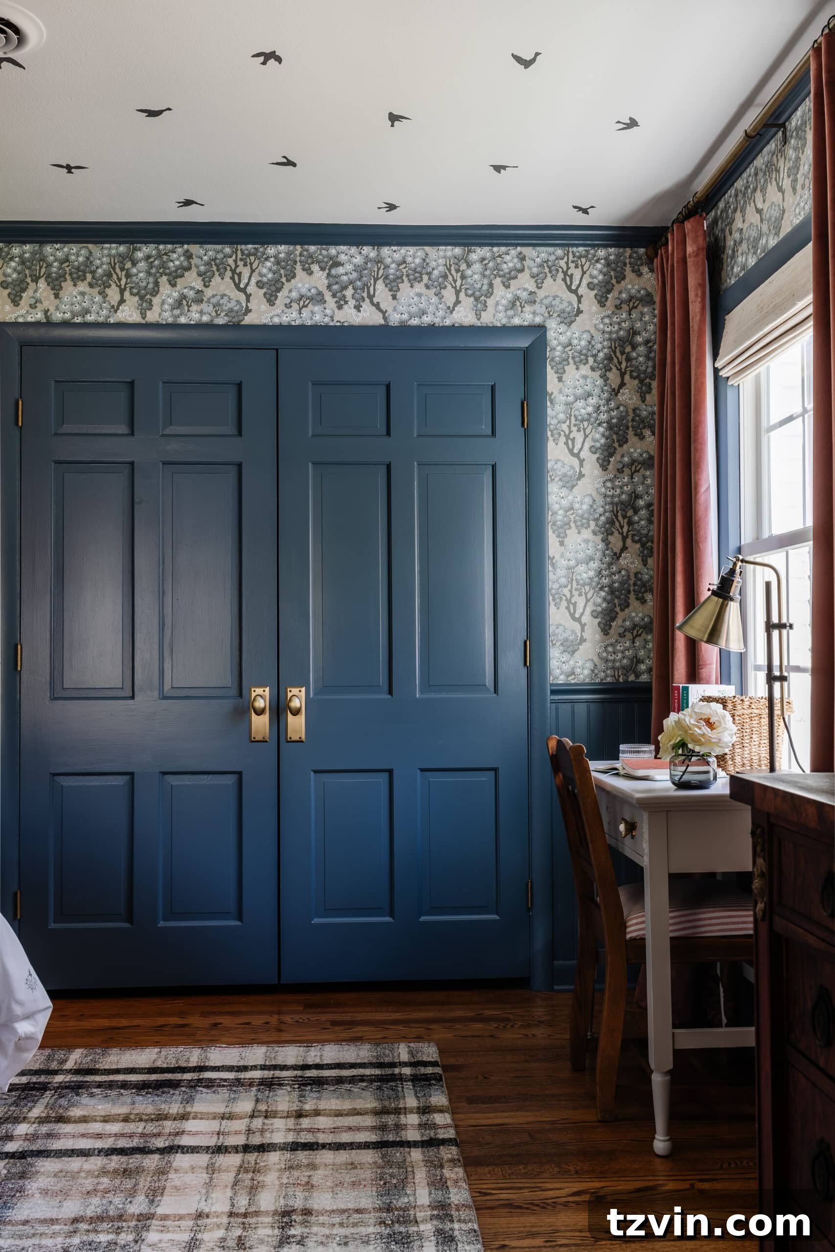 Double closet doors with antique gold knobs and desk in front of window