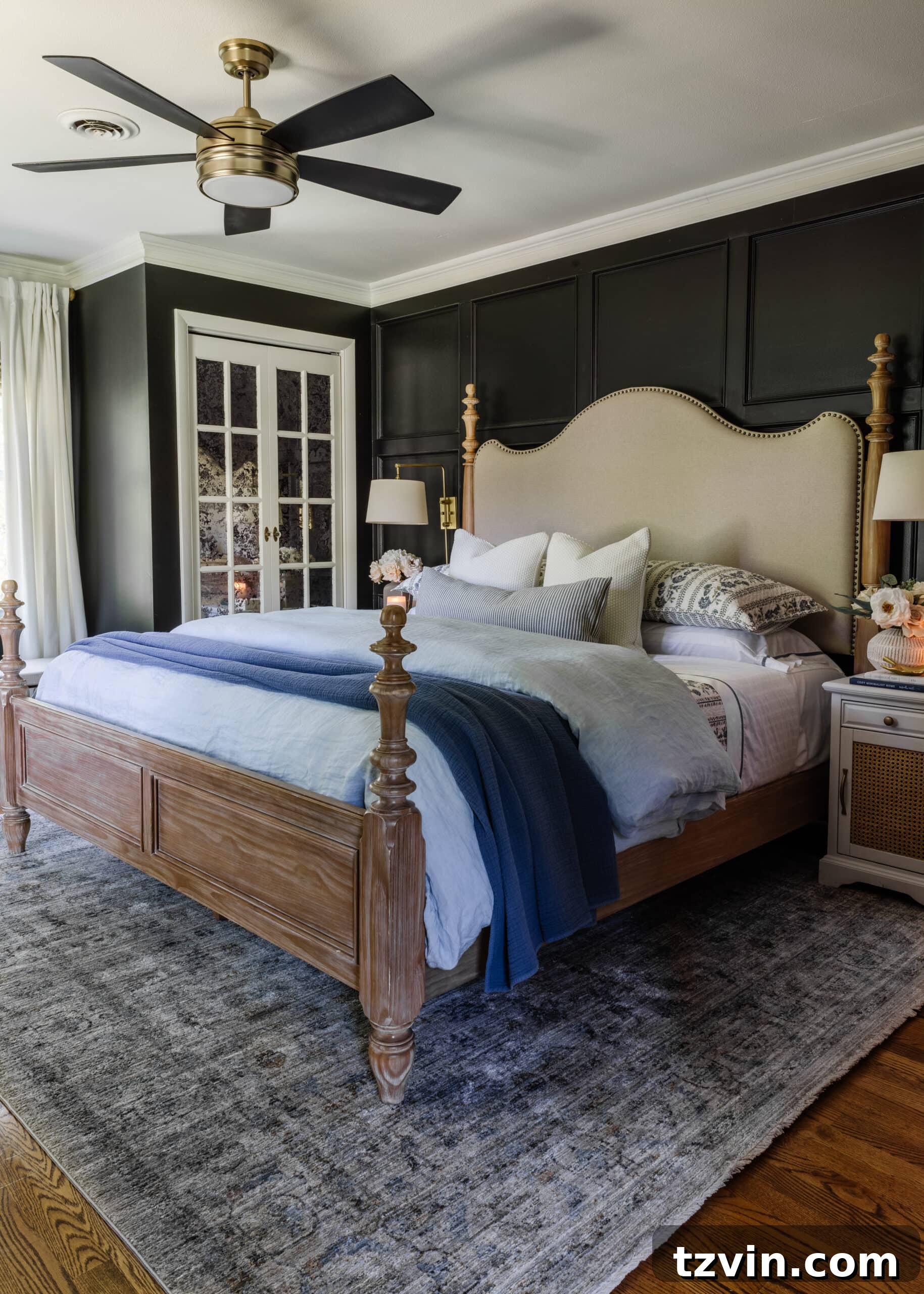 primary bedroom with poster bed, blue bedding, and a new rug from the Jean Stoffer line by Loloi