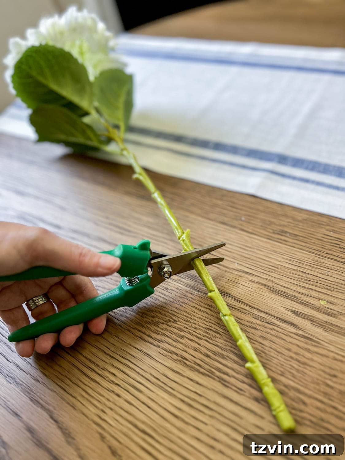 cutting a faux flower for a floral arrangement