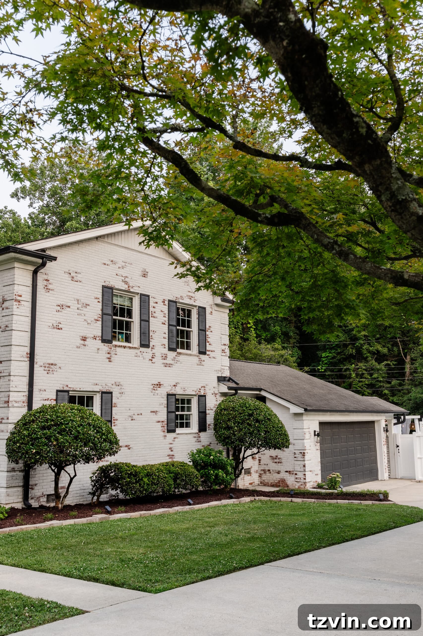 Mastering Limewashed Brick Cleaning and Upkeep 20 white limewashed brick with black gutters, black shutters, and black painted garage door