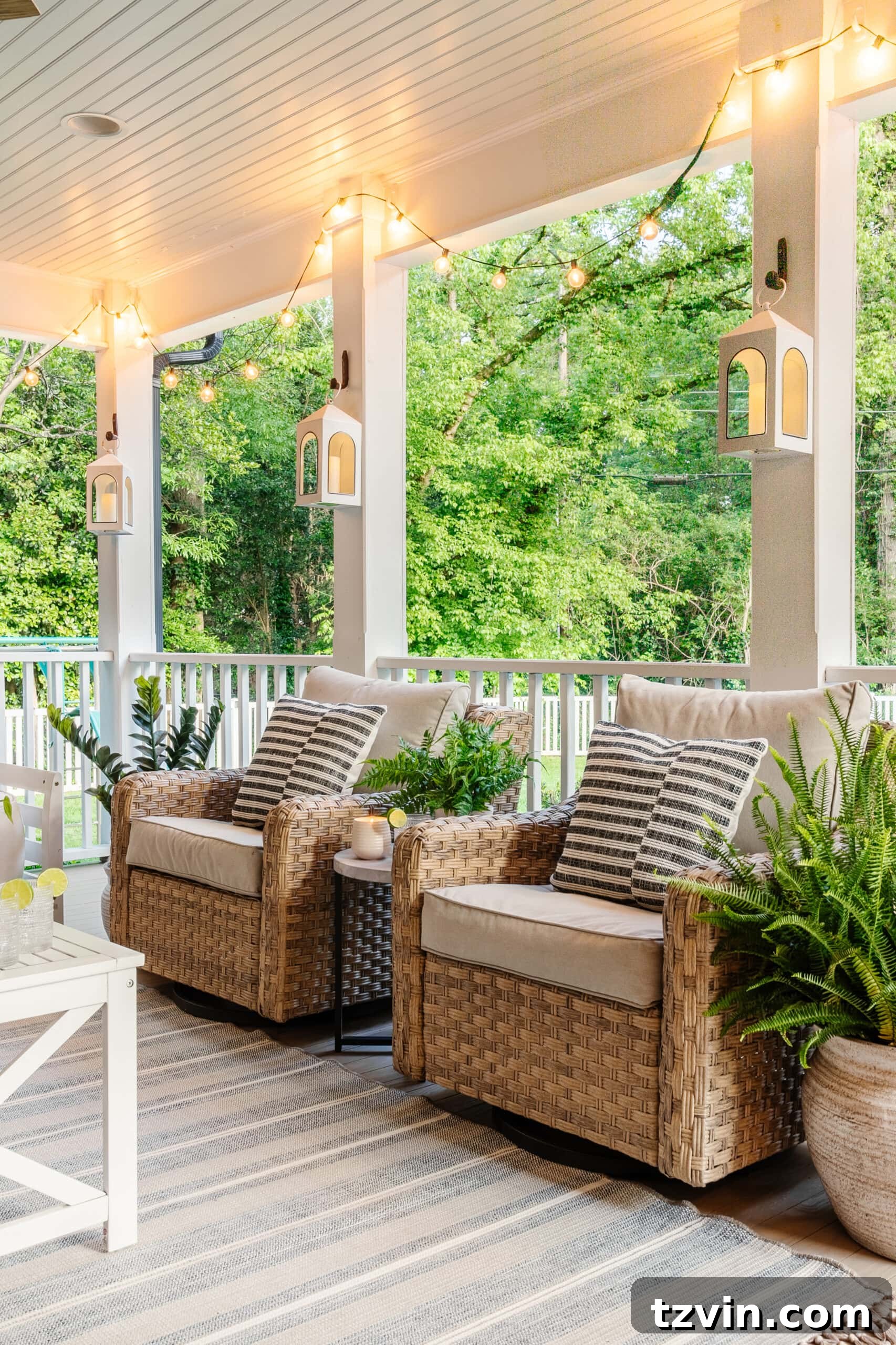 outdoor swivel chairs on a back porch with white coffee table and striped outdoor rug