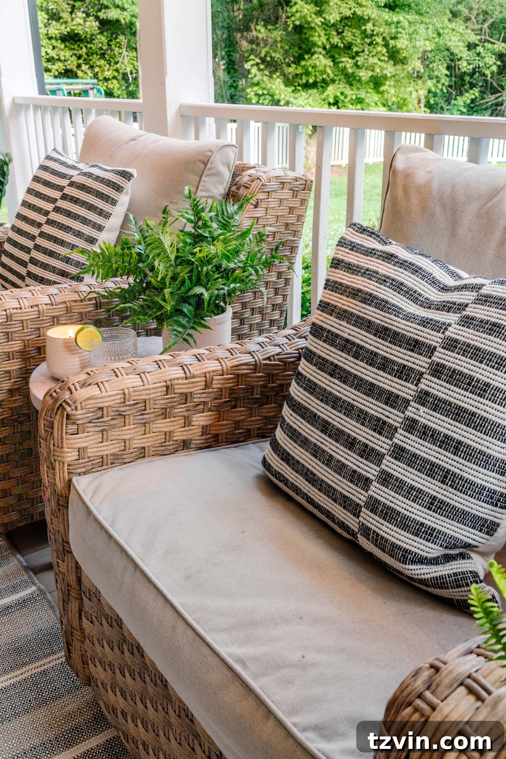 wicker swivel chairs on a back porch with striped black pillows
