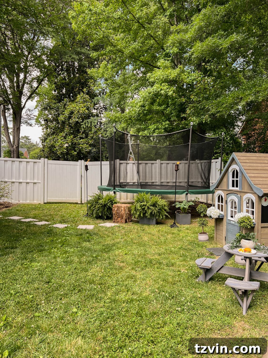 Elegant side yard with well-placed stepping stones leading gracefully to an inviting outdoor trampoline, designed for both aesthetic appeal and child's play.