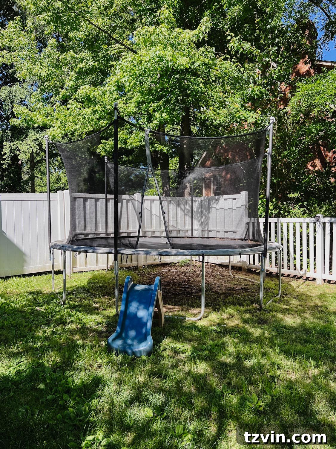 Before photo of a backyard trampoline, showing a worn pad and bare ground, highlighting the need for a side yard play area refresh.