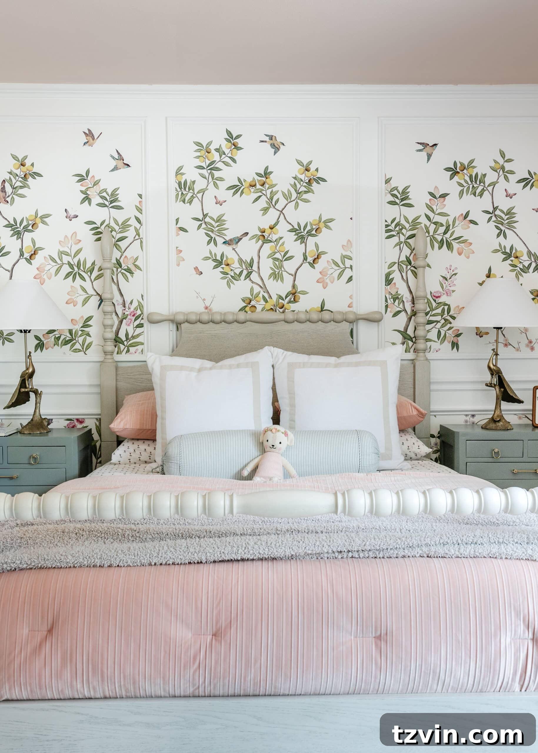 A cozy bedroom corner featuring a beige poster bed, delicate chinoiserie wallpaper, and soft pink bedding, creating a serene and inviting atmosphere.