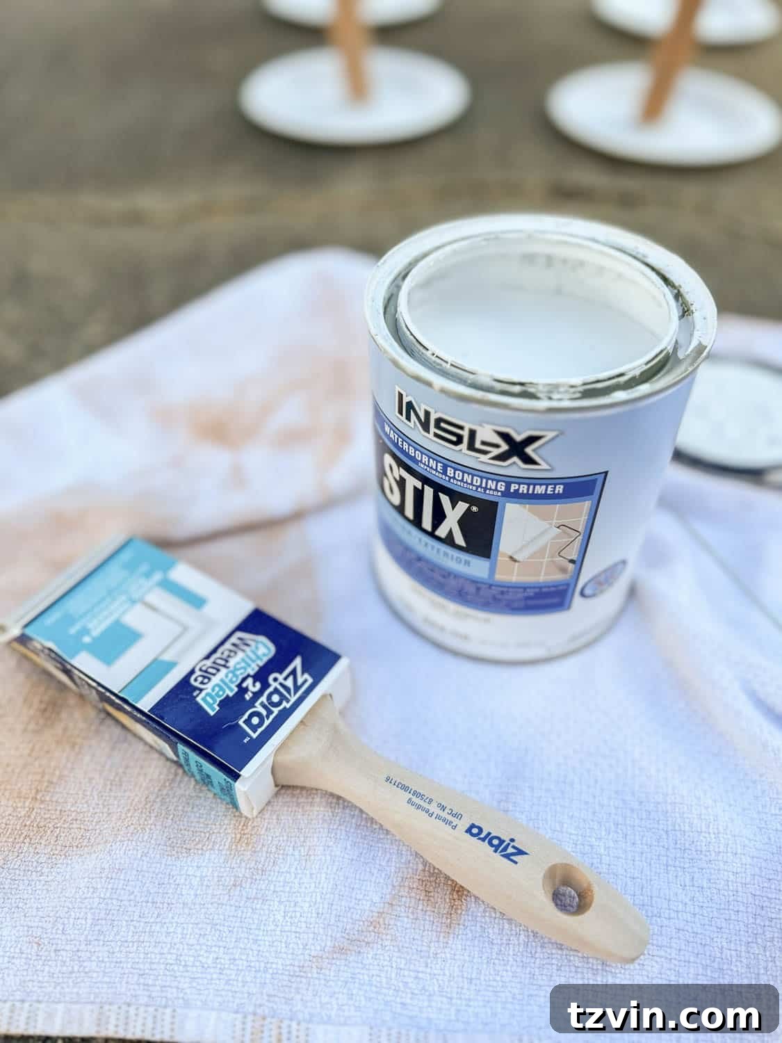 Applying INSL-X STIX Waterborne Bonding Primer to a sanded bedside table, demonstrating the crucial step for superior paint adhesion on furniture.