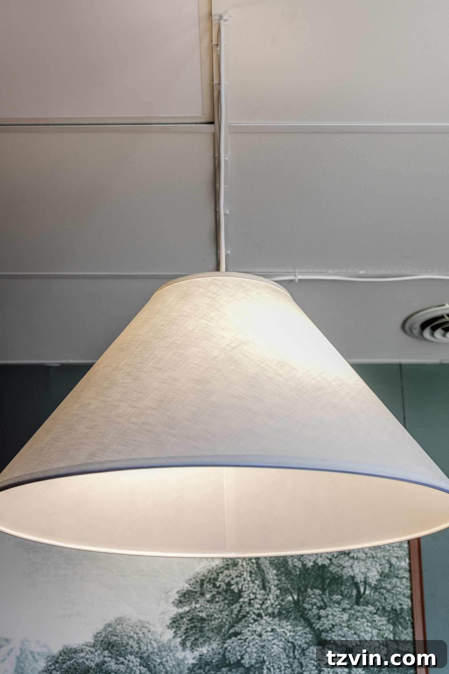 Warm Up Your Workday Cozy Conference Room Ideas for an Office Refresh 14 Close-up of a pendant light hanging above a conference table, demonstrating how soft lighting contributes to a welcoming and intimate setting.