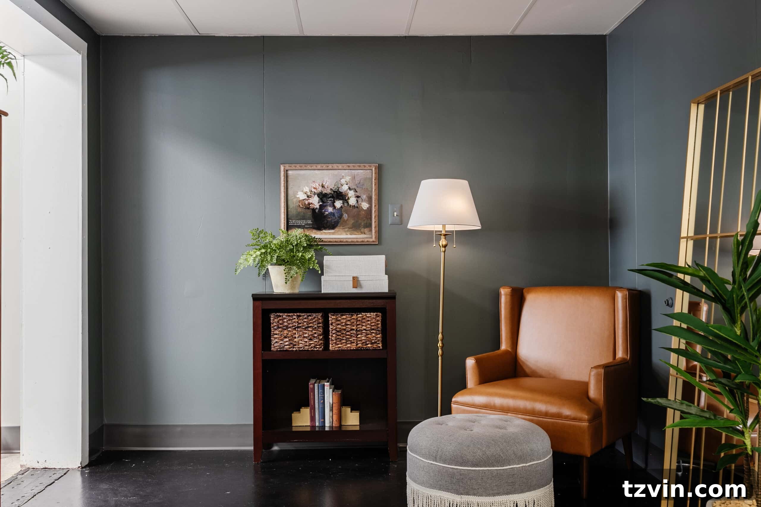 Warm Up Your Workday Cozy Conference Room Ideas for an Office Refresh 22 A welcoming reading corner in an office, complete with a leather armchair, fringe ottoman, and a repurposed bookshelf with discreet storage baskets.