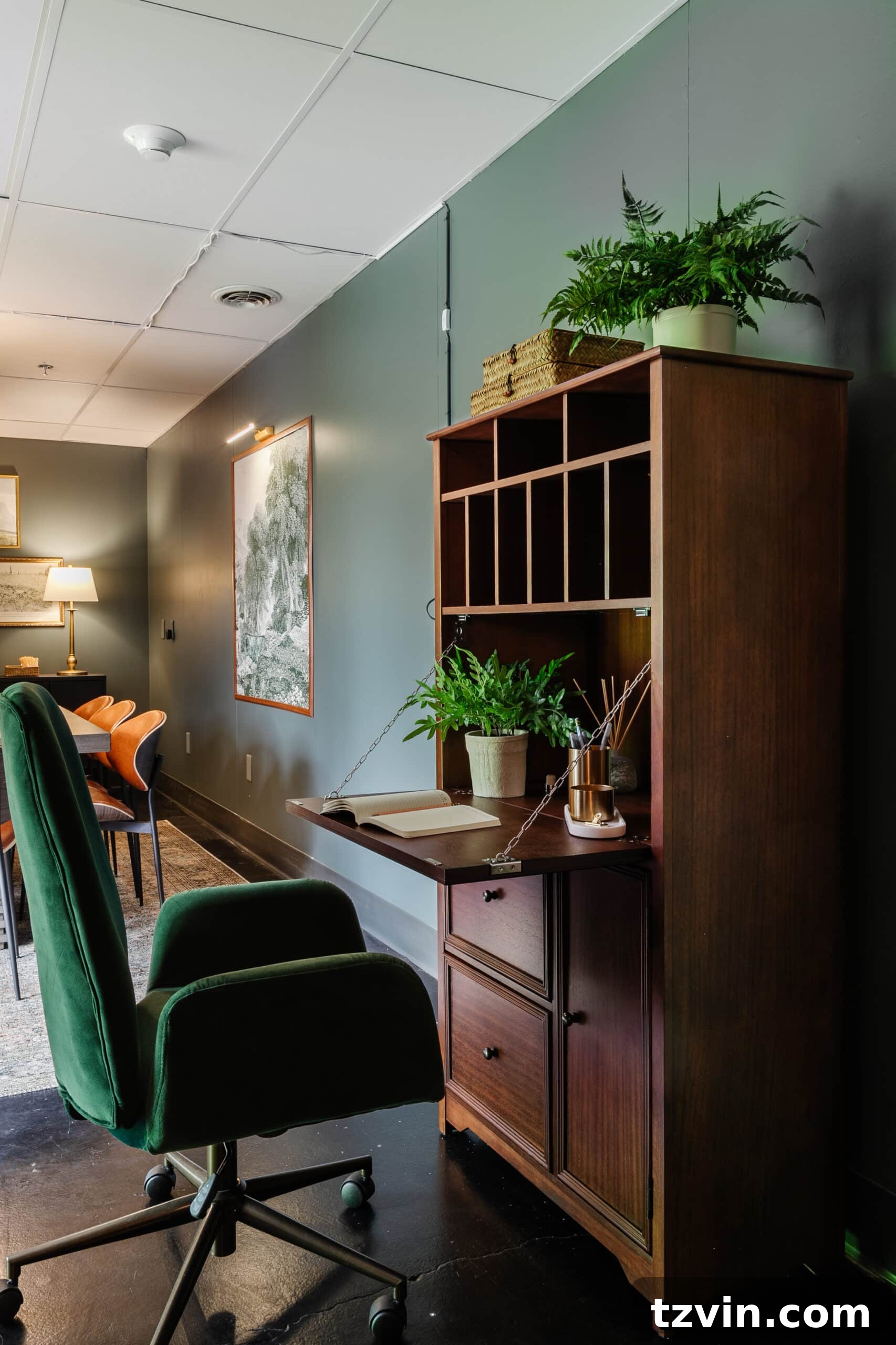 Warm Up Your Workday Cozy Conference Room Ideas for an Office Refresh 26 Elegant wooden secretary desk with its top folded down, revealing a neat workspace, complemented by a favorite green desk chair.