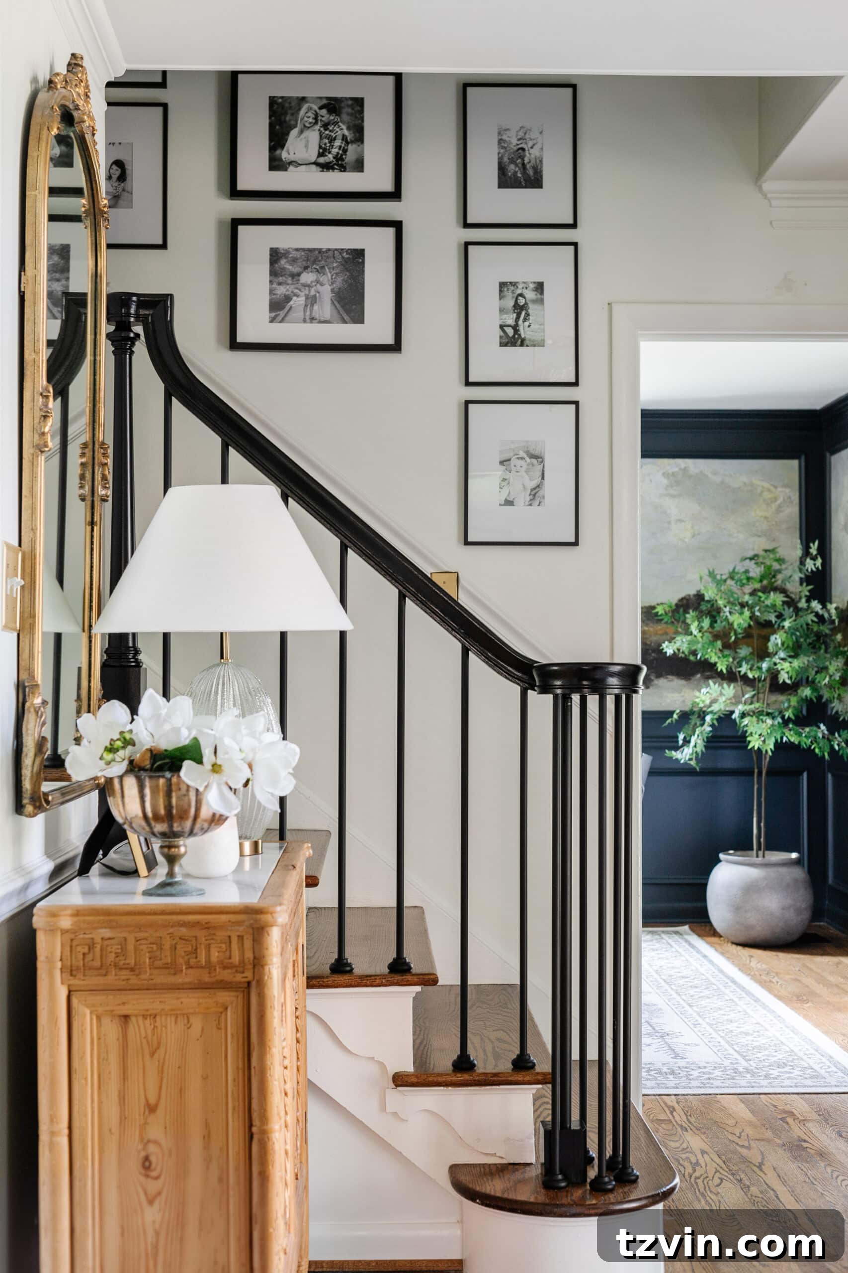 Hang Frames Perfectly Avoid These Common Errors 3 A black and white gallery wall elegantly ascending a staircase, demonstrating effective art placement.