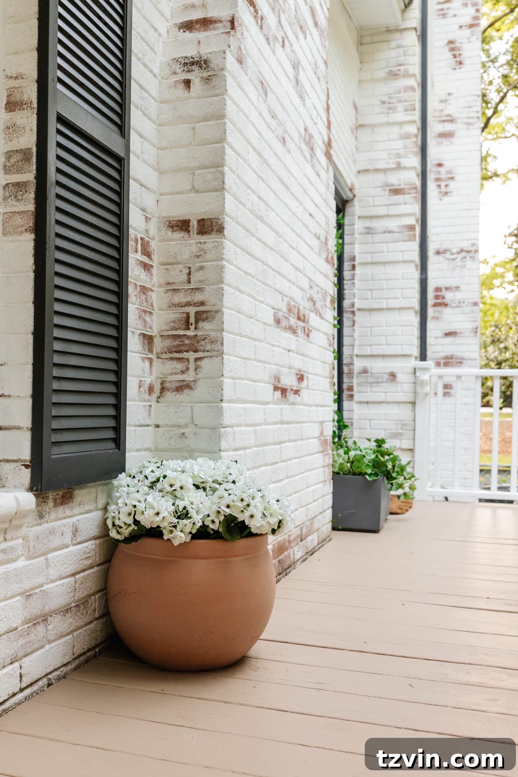 side porch makeover with terracotta planter of faux flowers