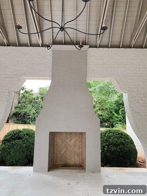 DIY Fireplace Creations for Any Space 19 A stunning covered porch fireplace featuring a unique, curvy design flanked by white brick.