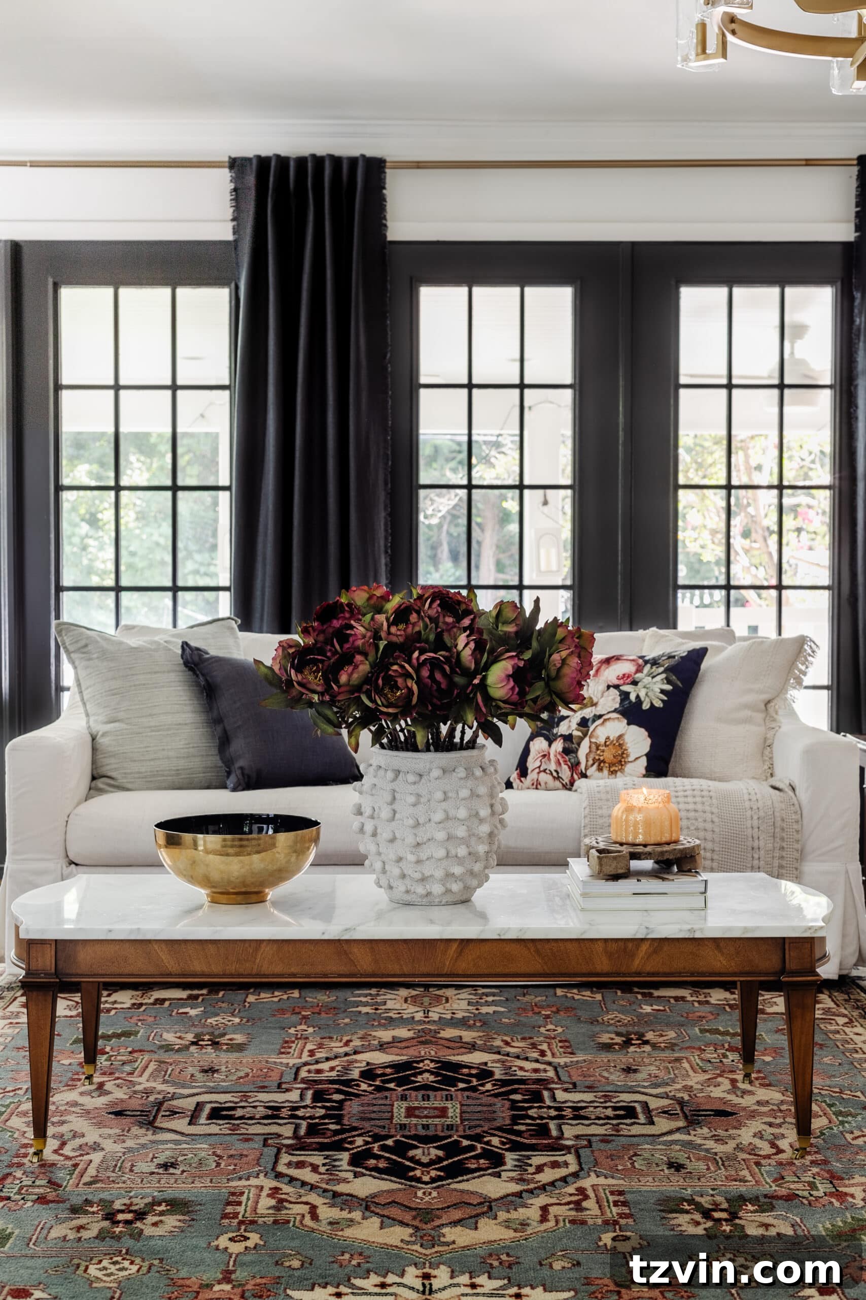 white living room sofa with marble coffee table decorated for fall with burgundy flowers