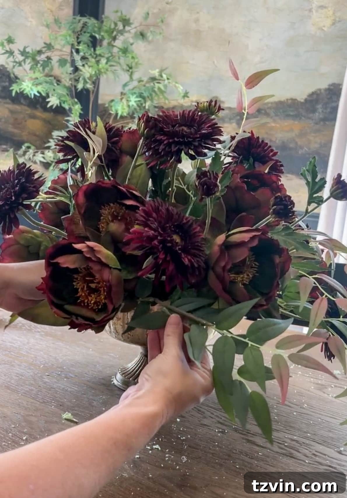 Your Guide to Crafting Beautiful Fall Floral Arrangements 13 Adding leafy stems around the base of a flower arrangement to hide foam and soften edges