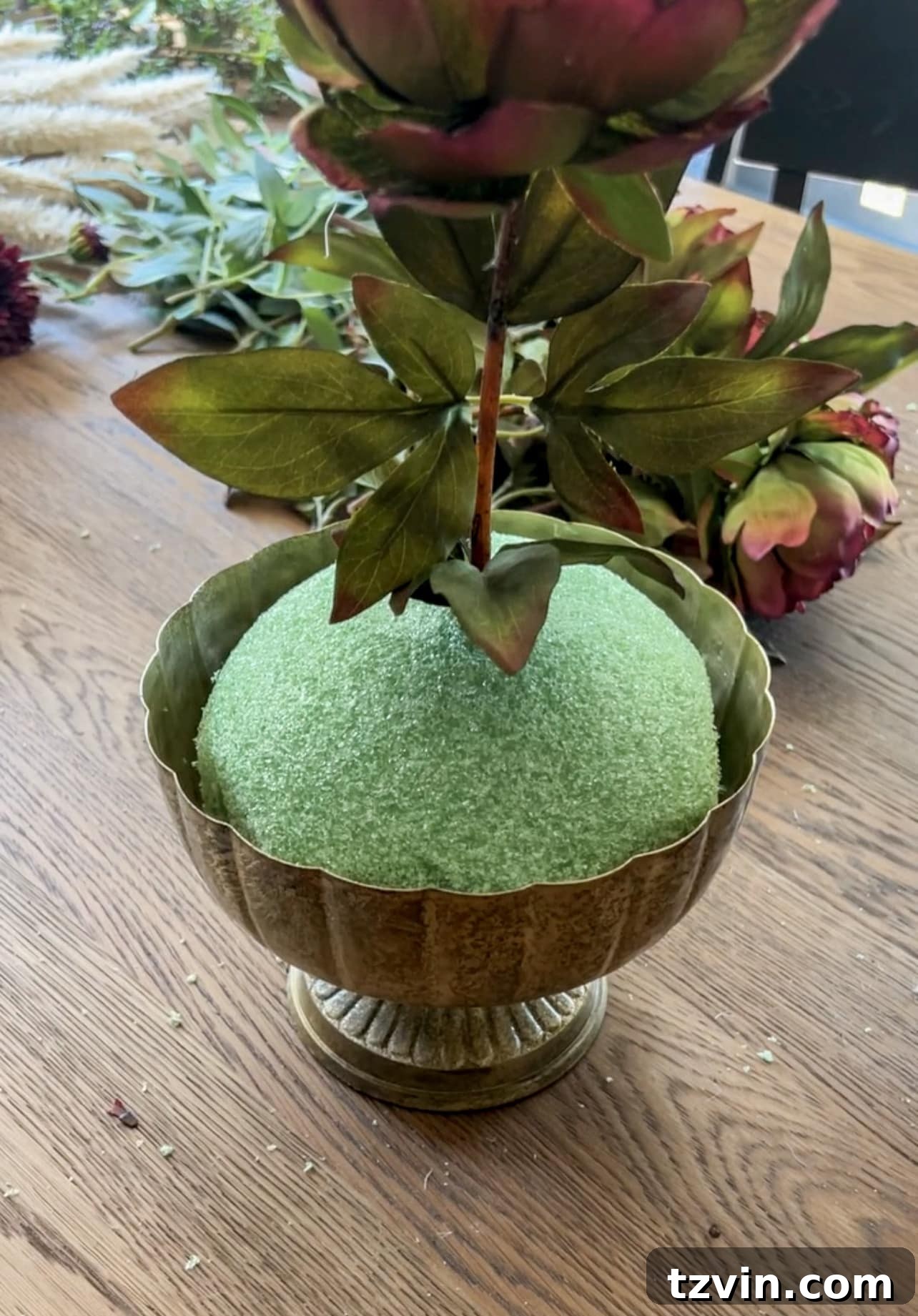 Your Guide to Crafting Beautiful Fall Floral Arrangements 6 Starting a floral arrangement by placing the first focal flower stem at the top center