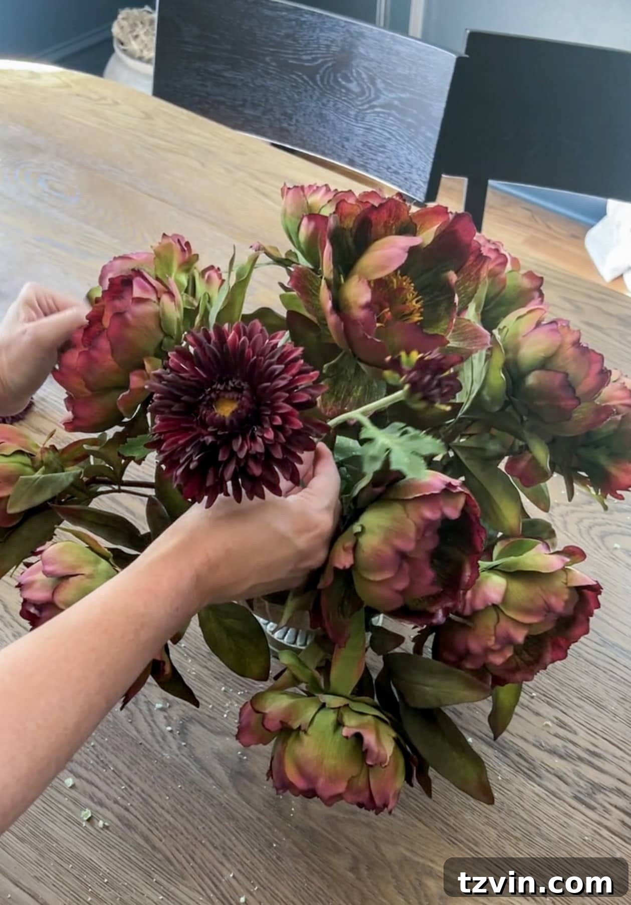 Your Guide to Crafting Beautiful Fall Floral Arrangements 10 Filling in a fall flower arrangement with burgundy mums to add dimension and color
