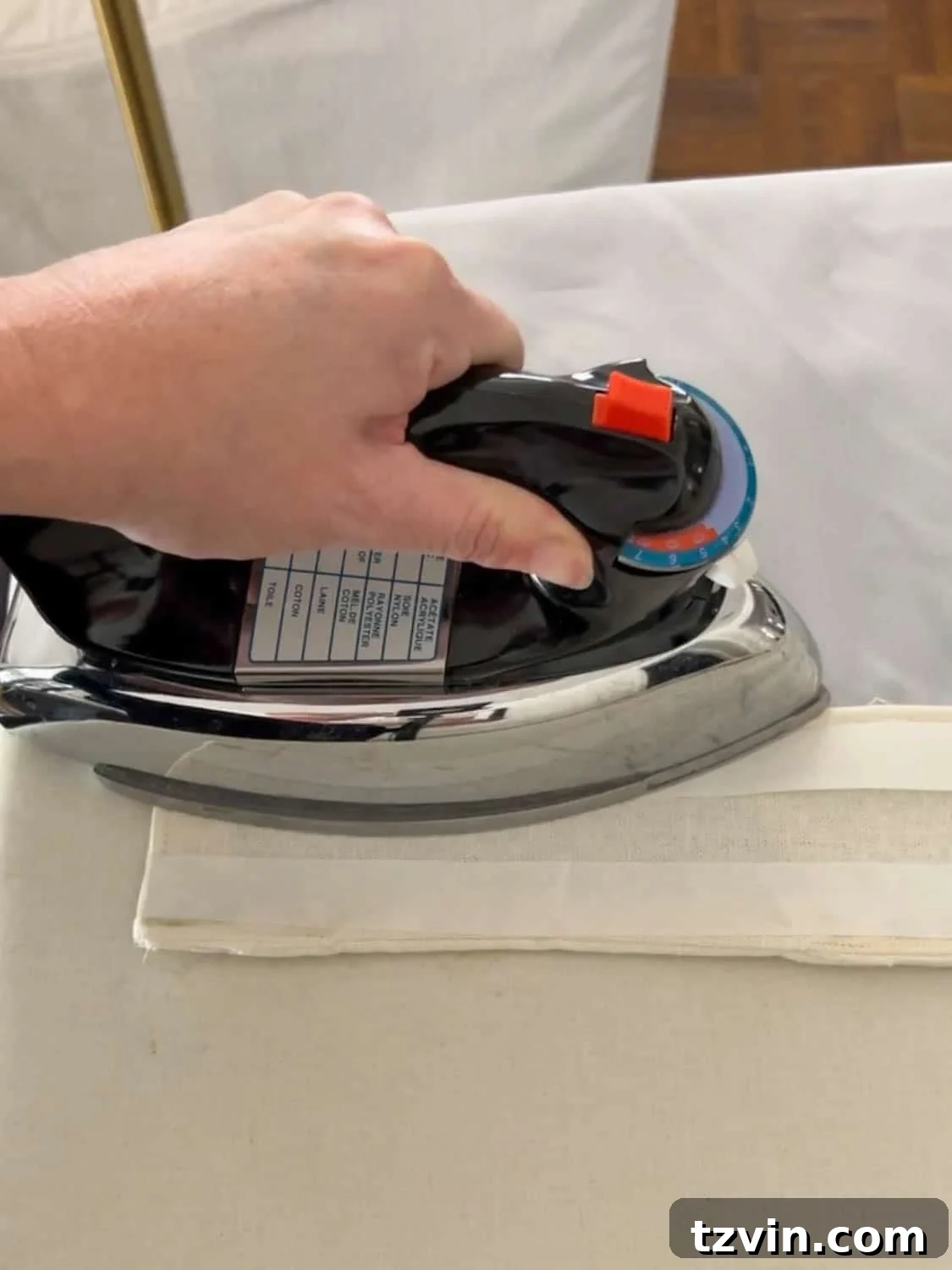 Chic No-Sew Curtains: Easy DIY with Designer Trim 9 Ironing hemming tape onto a curtain panel for a no-sew header application