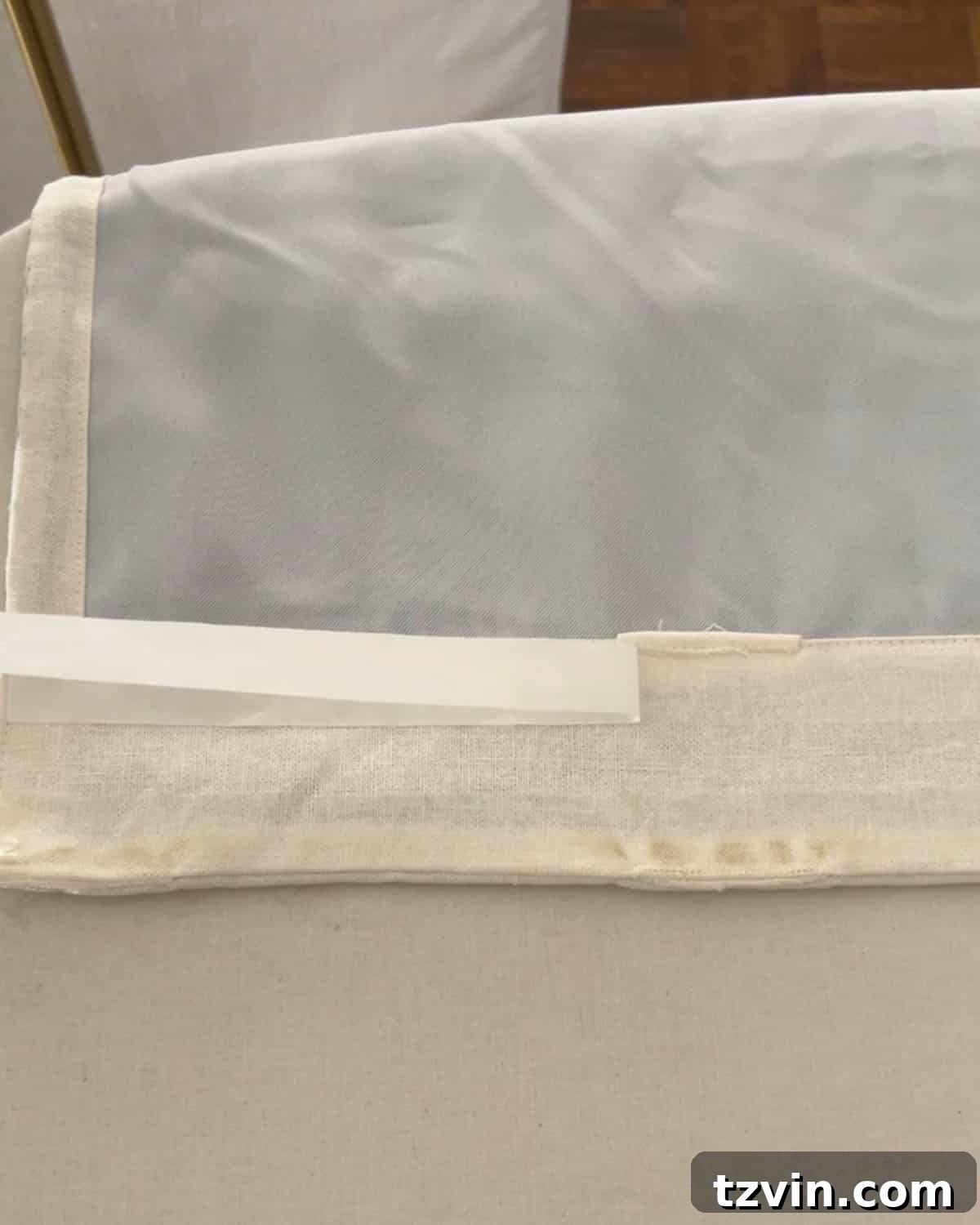 Chic No-Sew Curtains: Easy DIY with Designer Trim 10 Removing paper backing from hemming tape on curtain header, preparing for final iron