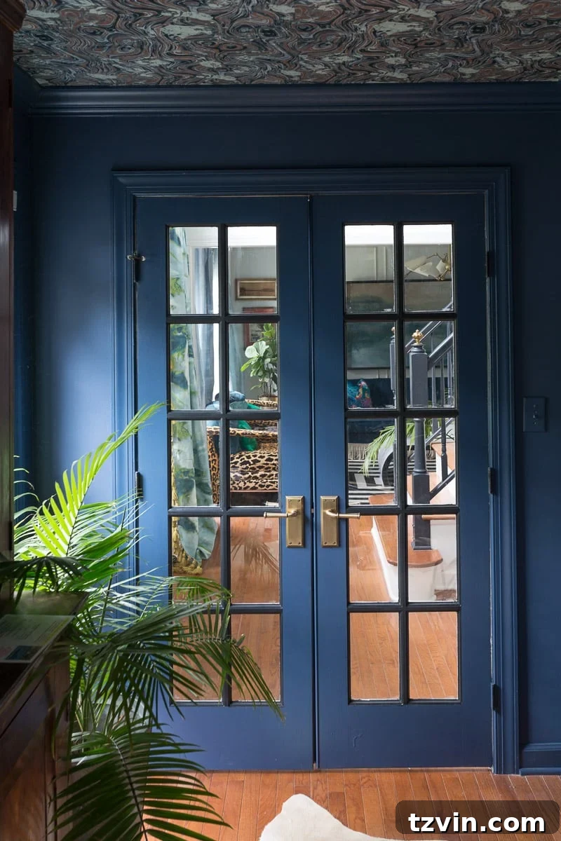 blue monochromatic french doors, trim, and walls with wallpapered ceiling