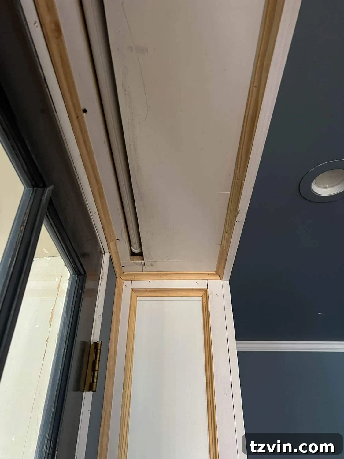 Akıllı IKEA Hack: Gizli Projeksiyon Perdesi Nasıl Yapılır 11 The cleverly designed hidden projector screen box positioned between bookcases above French doors, showcasing the opening for the screen