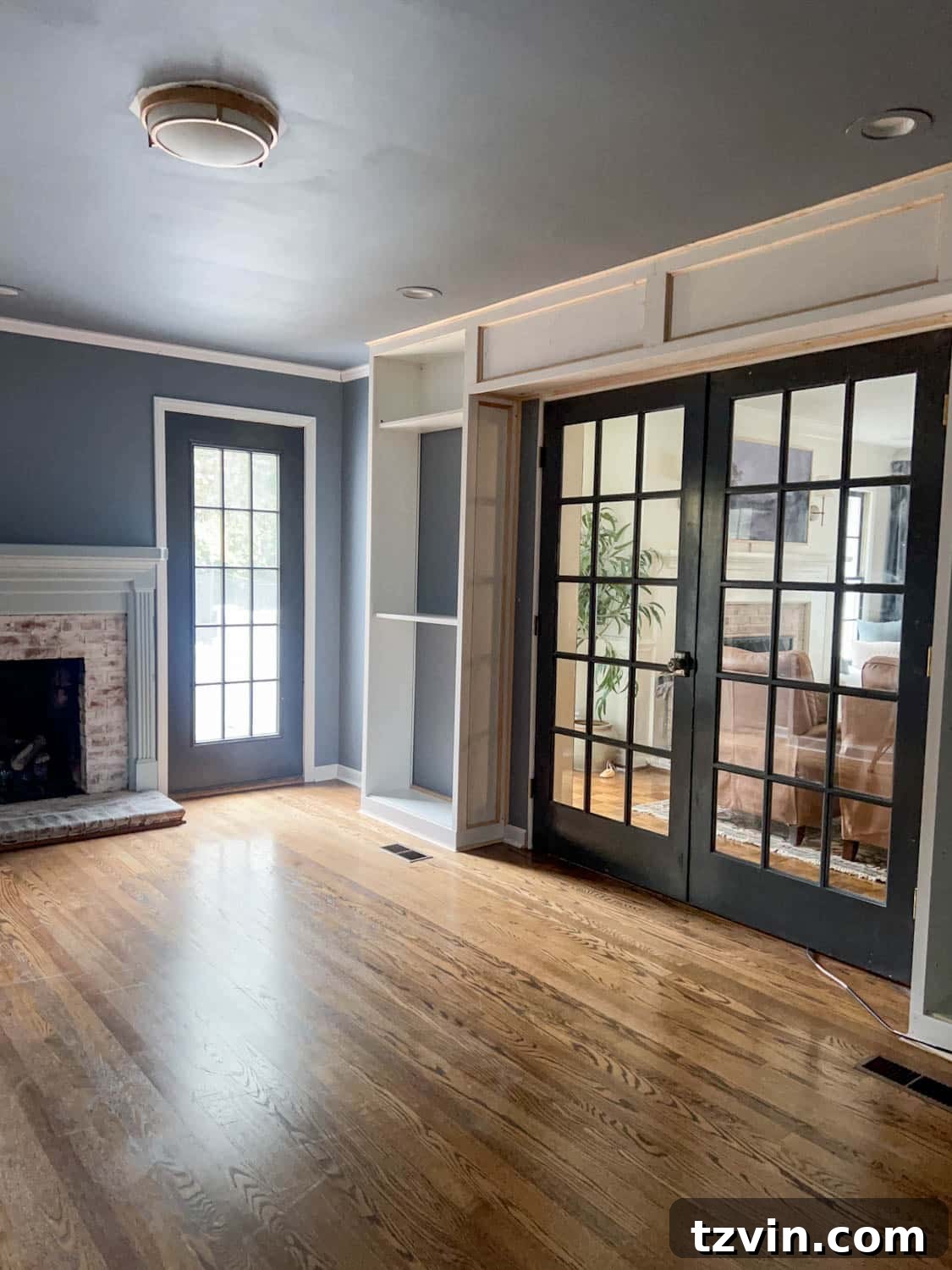 Akıllı IKEA Hack: Gizli Projeksiyon Perdesi Nasıl Yapılır 3 Elegant French doors flanked by custom built-in IKEA bookshelves, framing the hidden projector screen