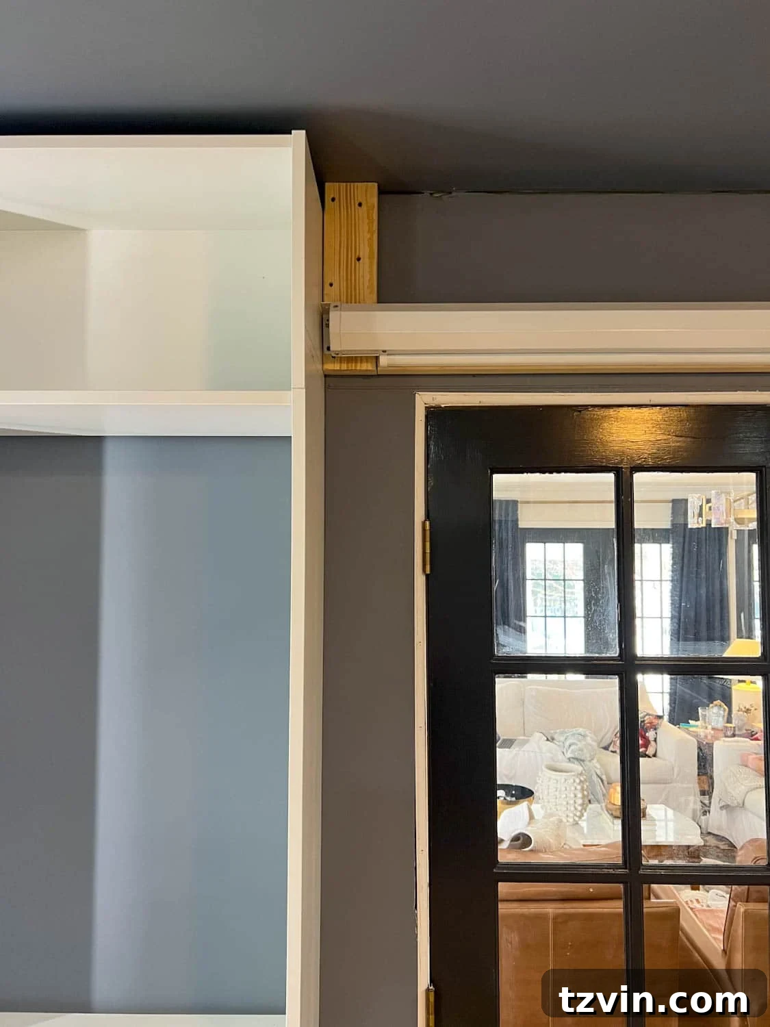 Akıllı IKEA Hack: Gizli Projeksiyon Perdesi Nasıl Yapılır 7 Process of hanging an electric projector screen on the wall, secured by 2x4 supports, between built-ins