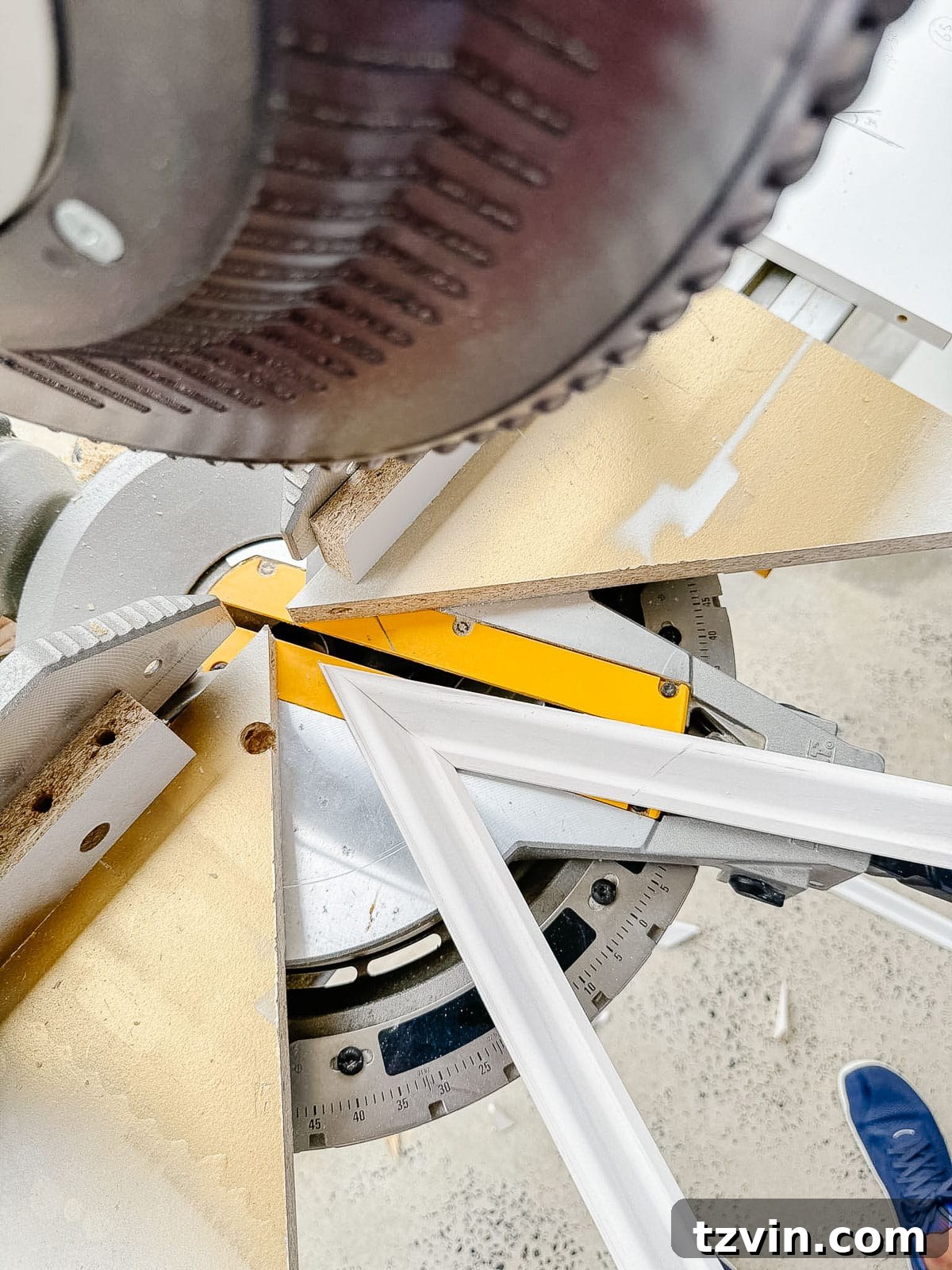 Stair Wainscoting Made Simple: A DIY Installation 11 Angled molding being cut on a miter saw for intricate wainscoting details
