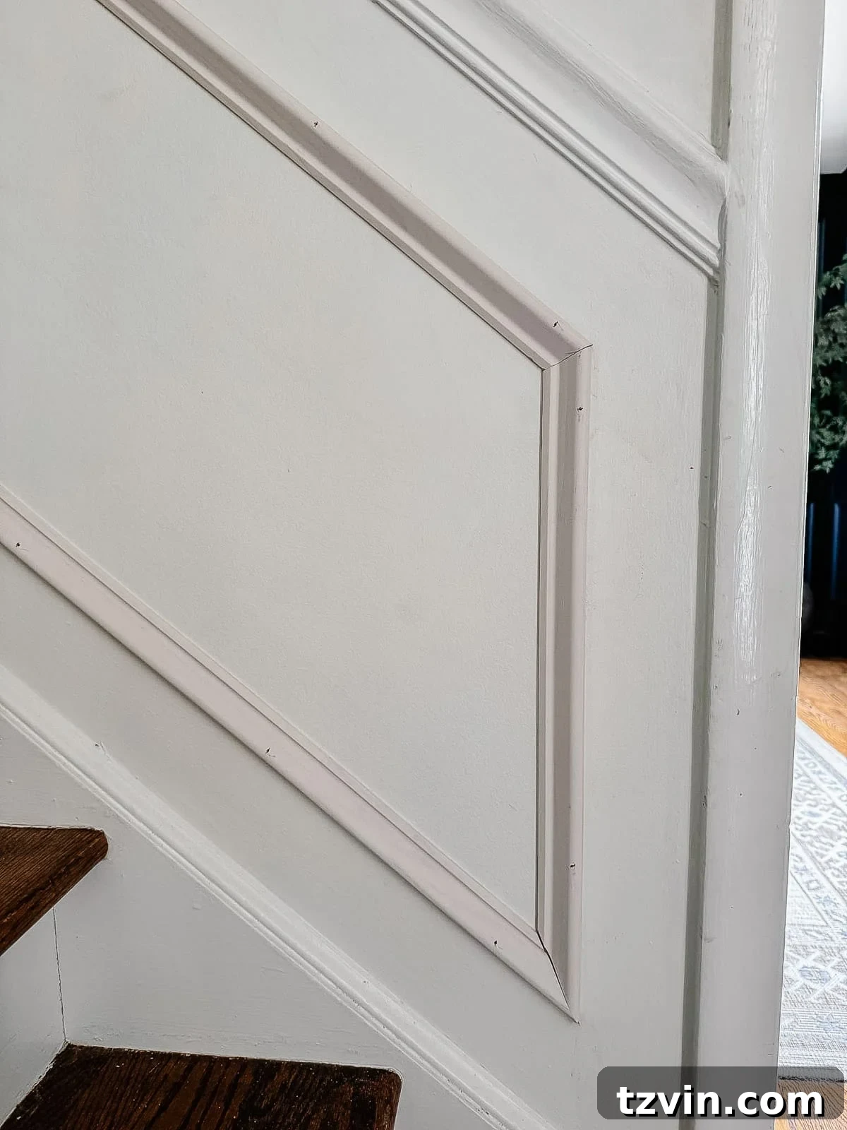 Stair Wainscoting Made Simple: A DIY Installation 12 Close-up of angled picture frame molding seamlessly installed on stairs
