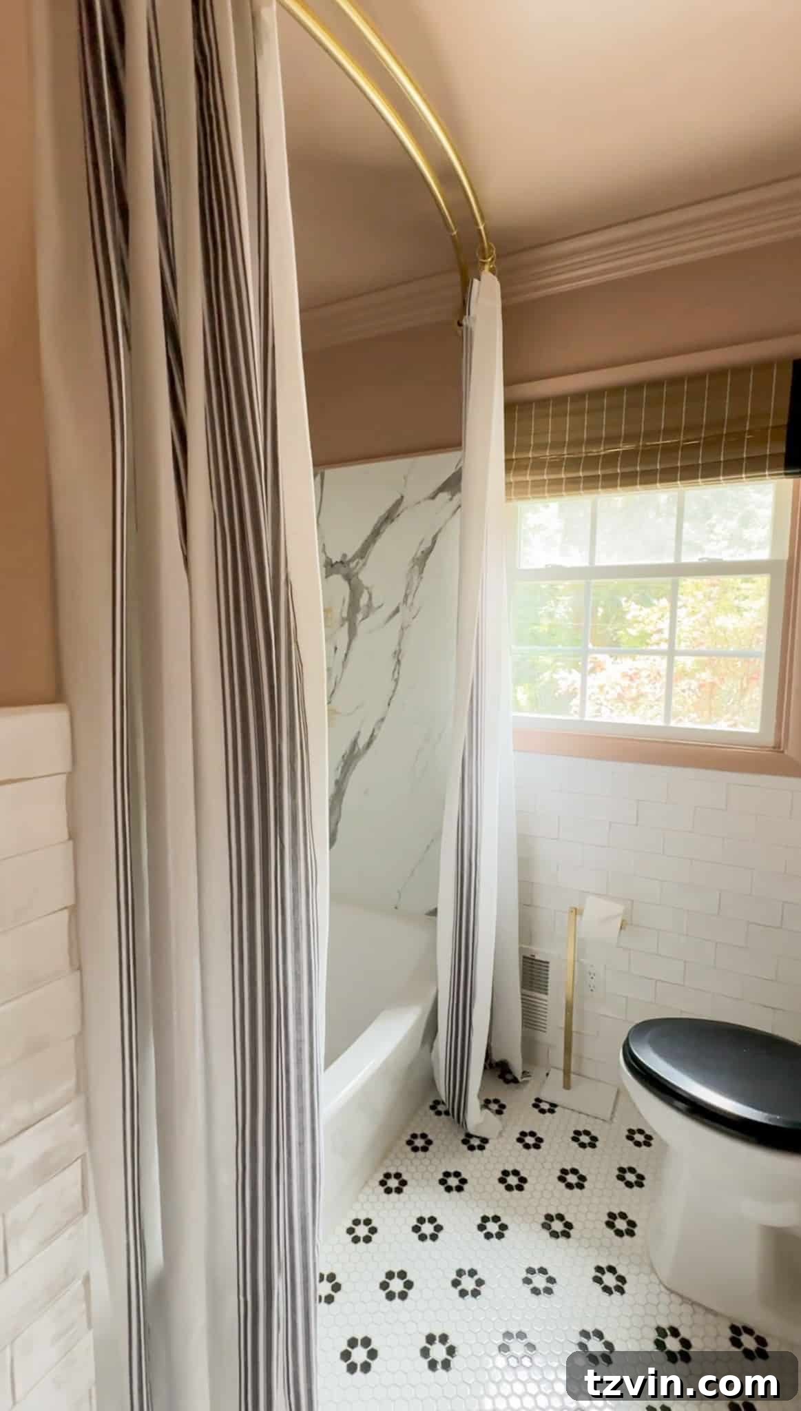A beautifully styled bathroom featuring a long, flowing double curtain panel used as a shower curtain, enhancing the room's height and creating a luxurious atmosphere. The sophisticated fabric adds texture and color.