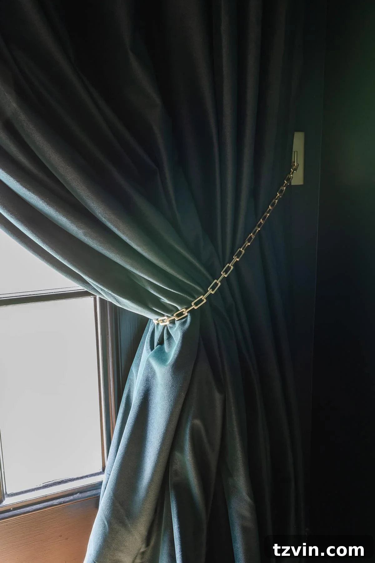 Effortless Ways to Open Single Panel Drapes and Home Theater Curtains 7 Close-up of a gold chain curtain tieback elegantly holding back a velvet drape.
