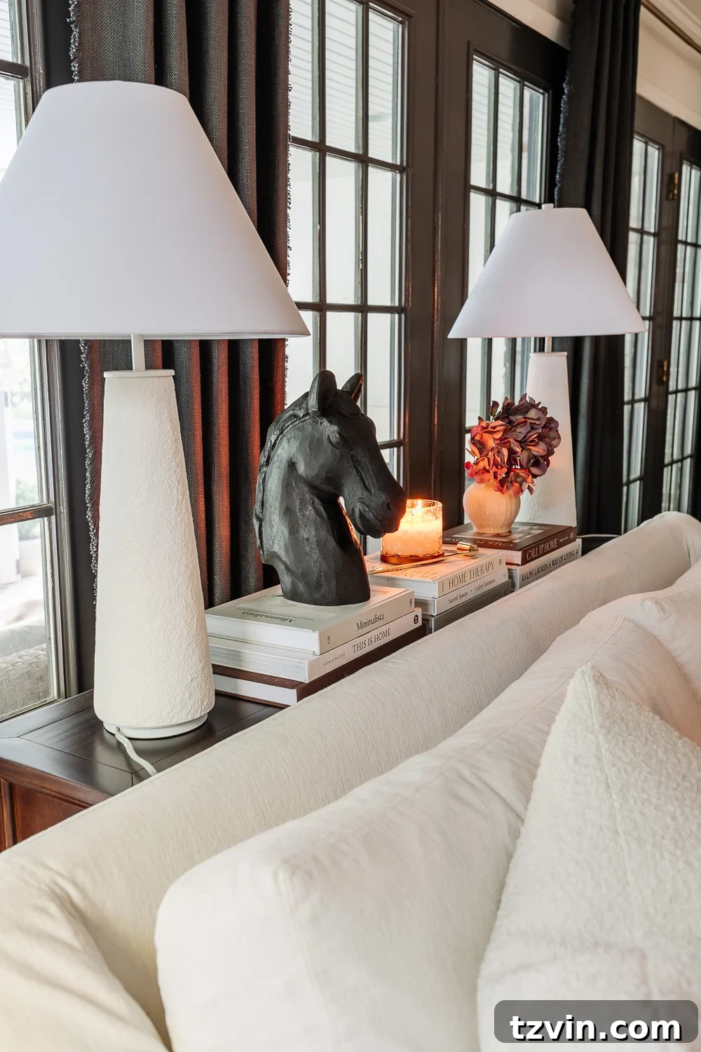 The Sofa Table Mistake You're Making 6 Sofa table decor ideas featuring lamps, books, and candles in a curated display