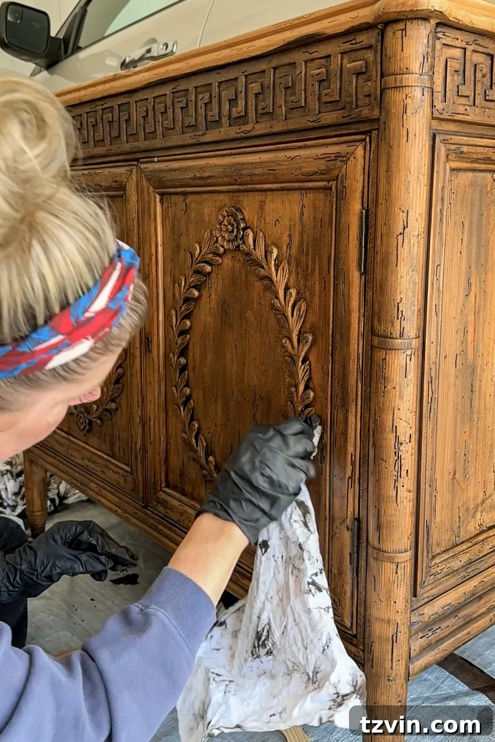 Renew Stained Furniture Without Sanding 9 Wiping away excess gel stain from the wood cabinet surface after the first coat, revealing the new wood tone.