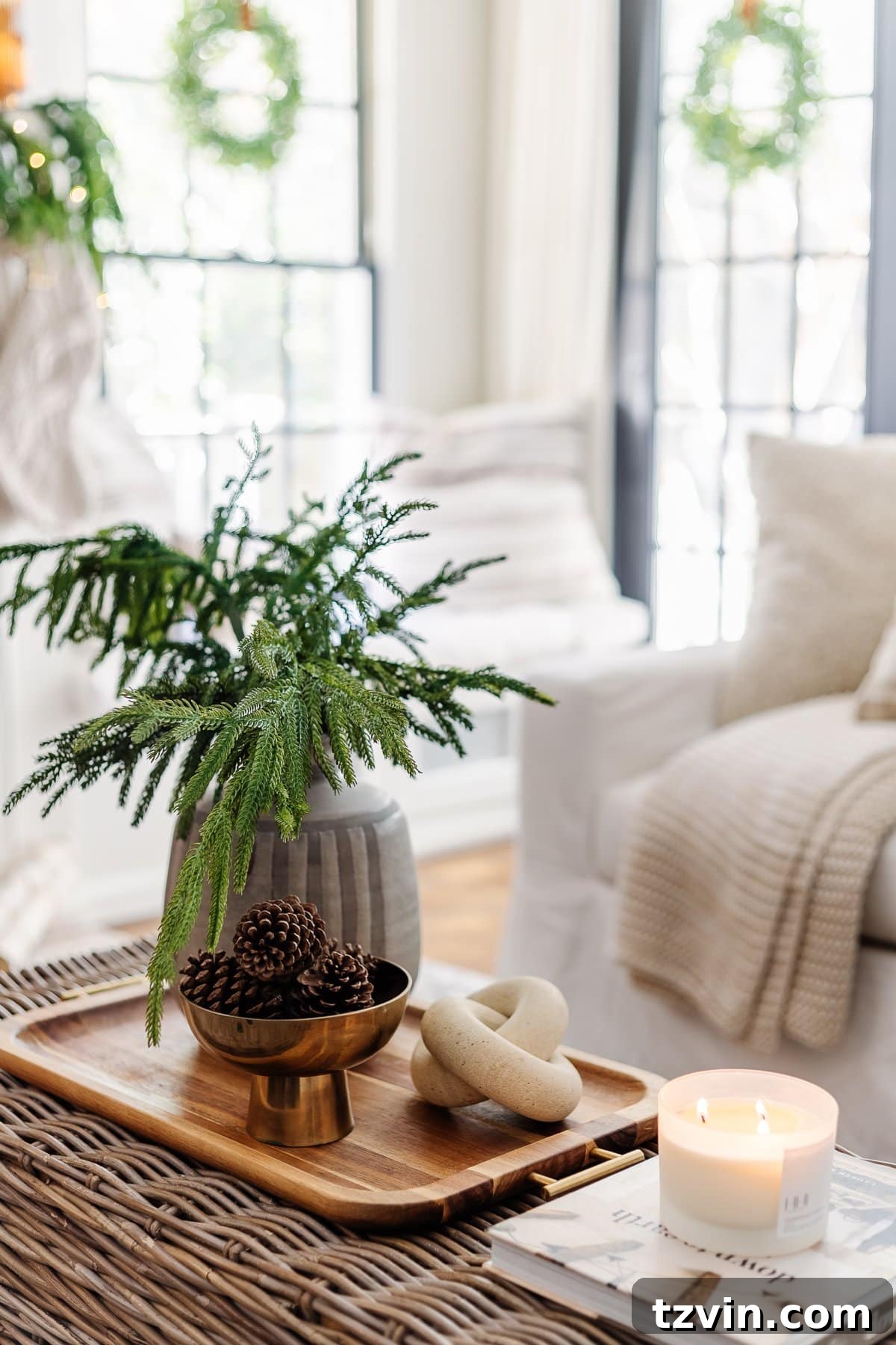 Coffee table winter decor in a living room, featuring a bowl of pinecones and a vase of evergreen stems for natural seasonal charm.